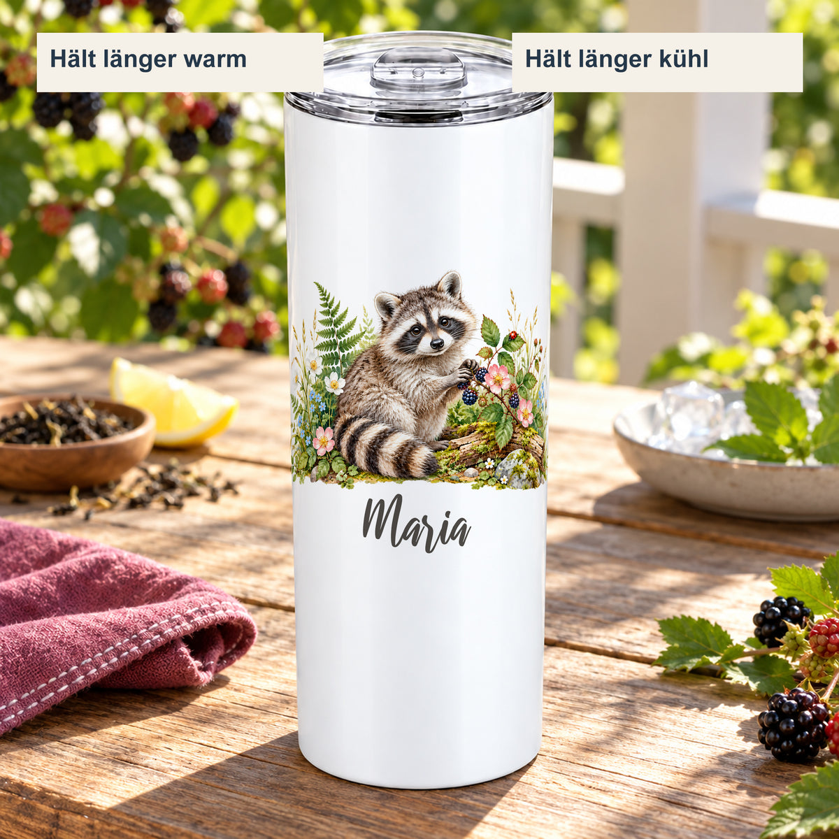 Thermobecher mit Waschbär-Motiv in einer sommerlichen Getränkeszene mit Hinweisen auf länger warme und länger kühle Getränke.
