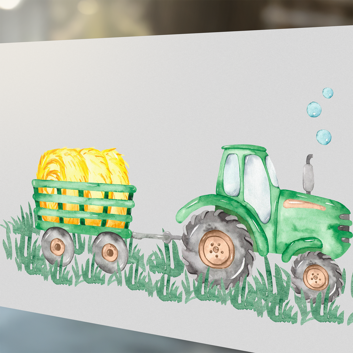 Grüner Traktor mit gelbem Heuballen auf Anhänger.