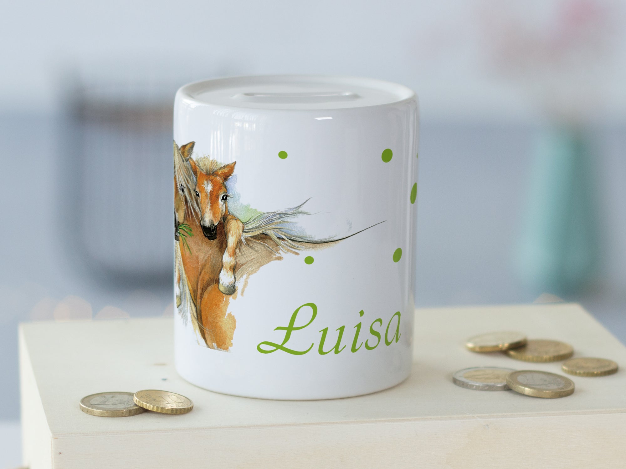 Weiße Spardose mit Pferdemotiv und grüner Schrift "Luisa".