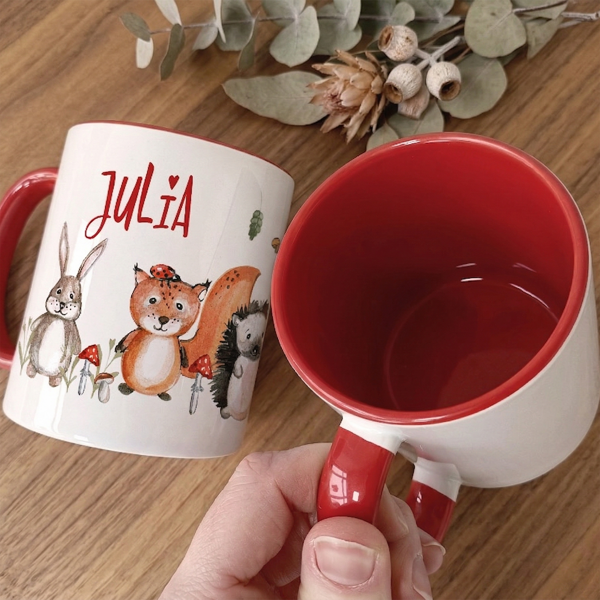Personalisierte Tasse mit roten Henkel und Tiermotiven.