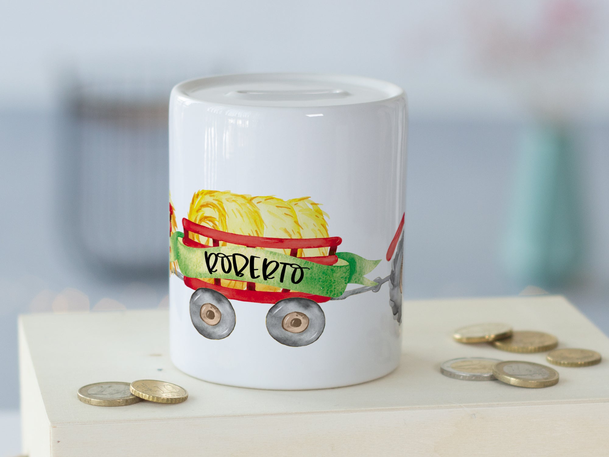 Weißer Keramikbecher mit buntem Wagen und Heu.