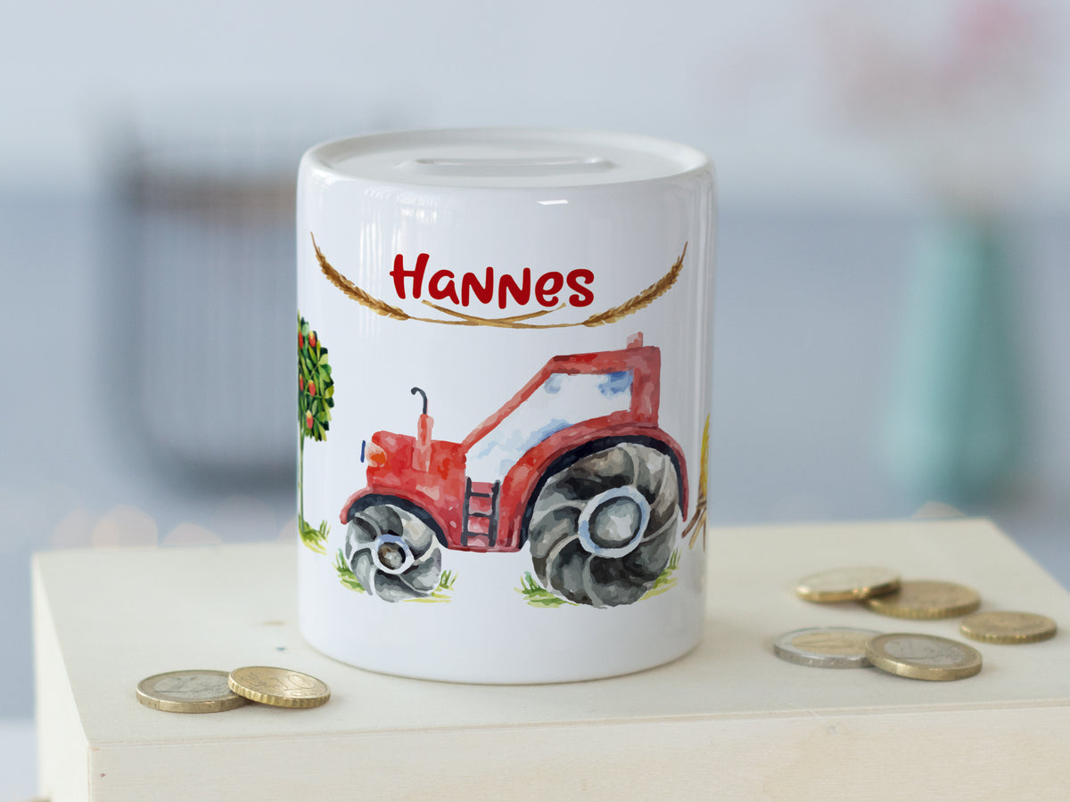 Weißes Sparschwein mit rotem Traktor und Namen "Hannes".