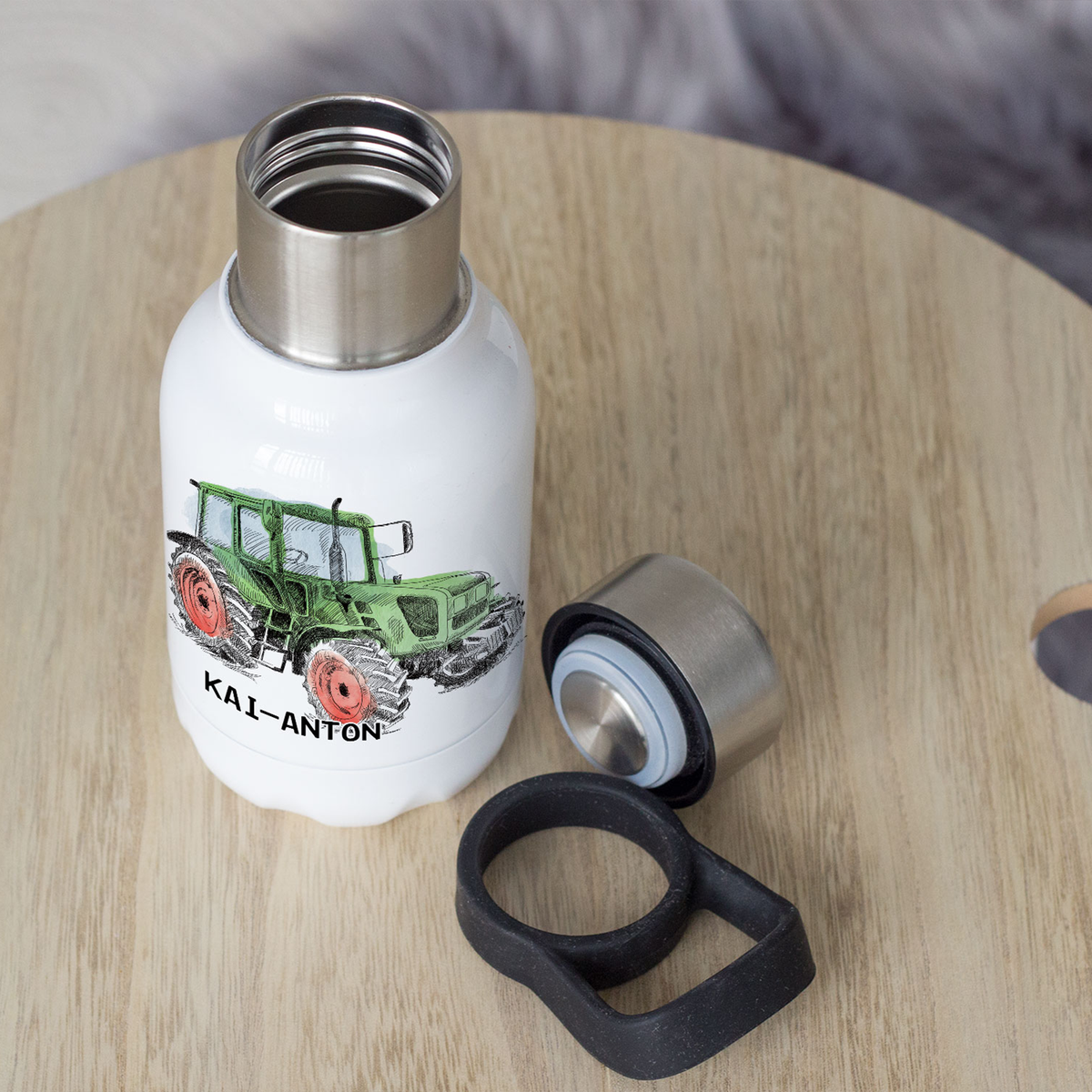 Weiße Trinkflasche mit grünem Traktor und Namen.