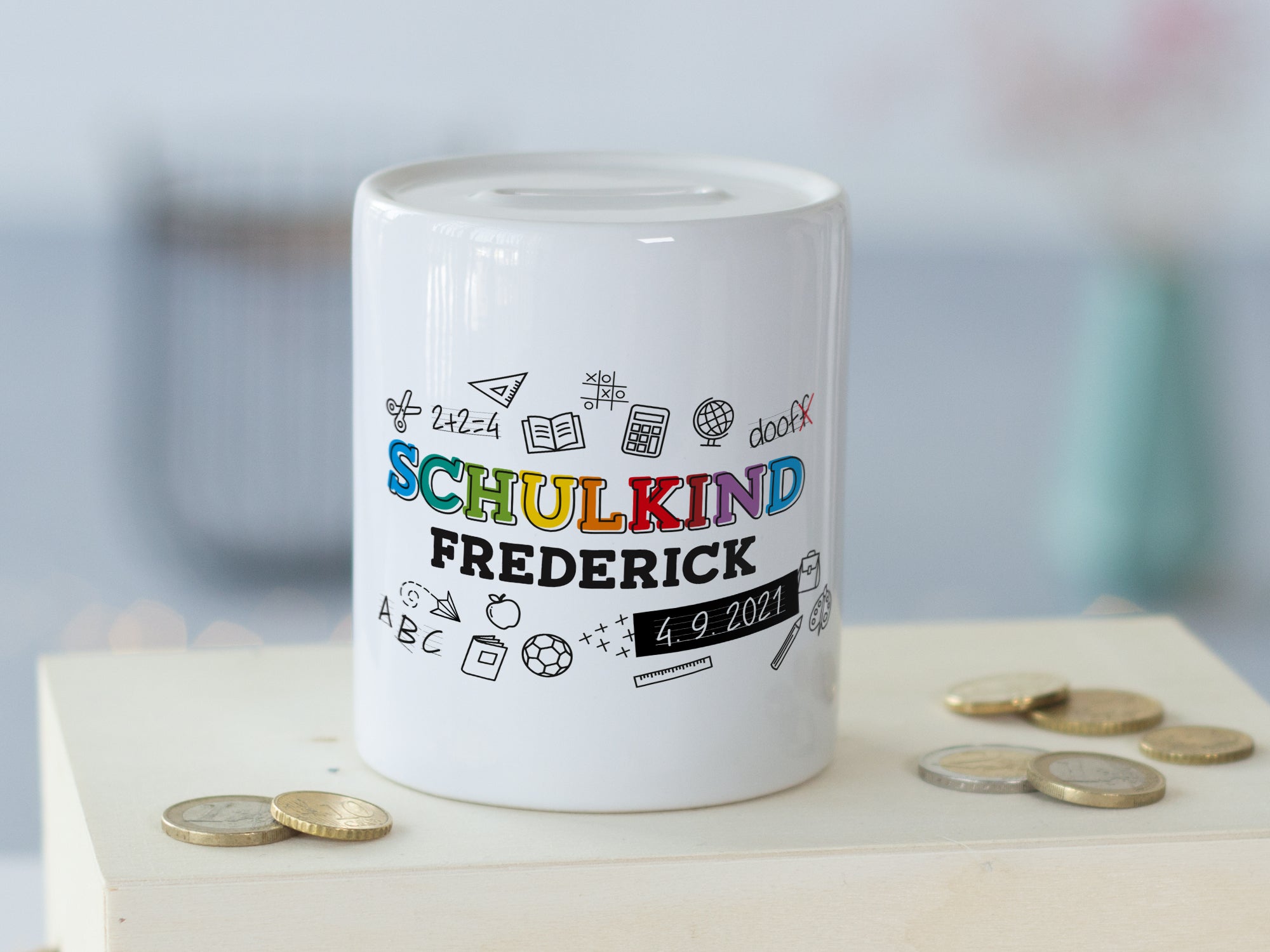 Weißes Sparschwein mit buntem "Schulkind" und Namen.