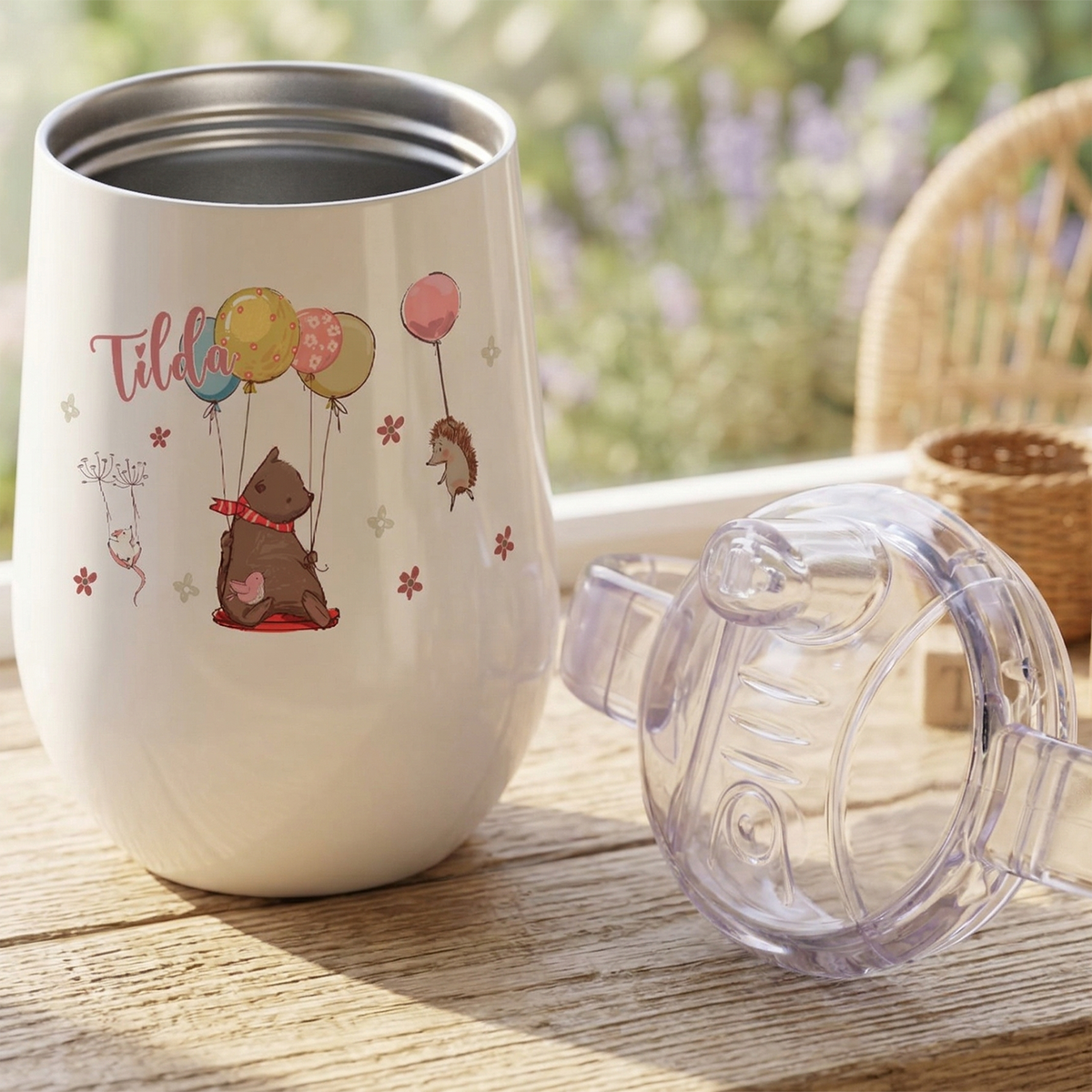 Weißer Becher mit Tiermotiven und bunten Luftballons.