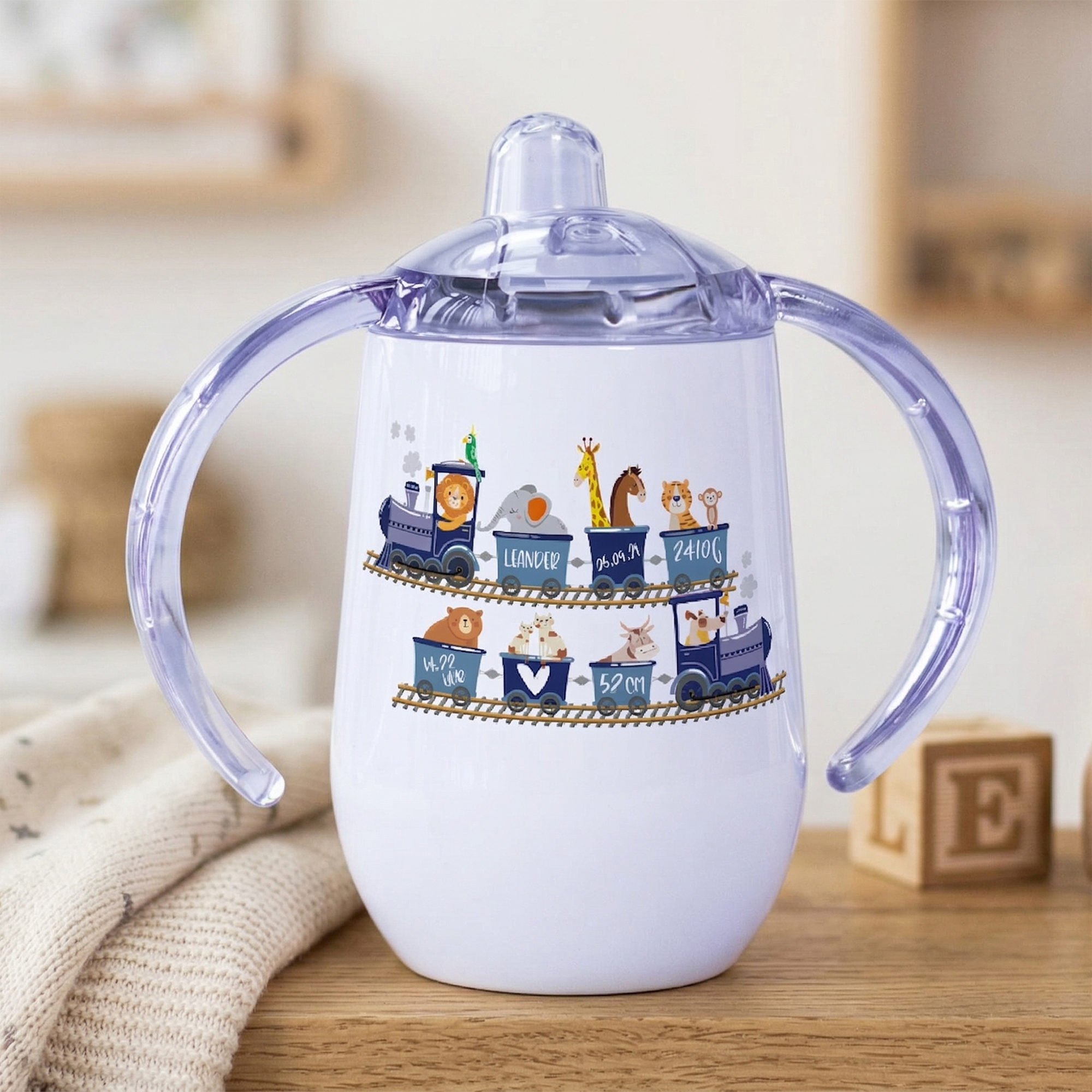 Sippy Cup mit Tiermotiven in lila und weiß.
