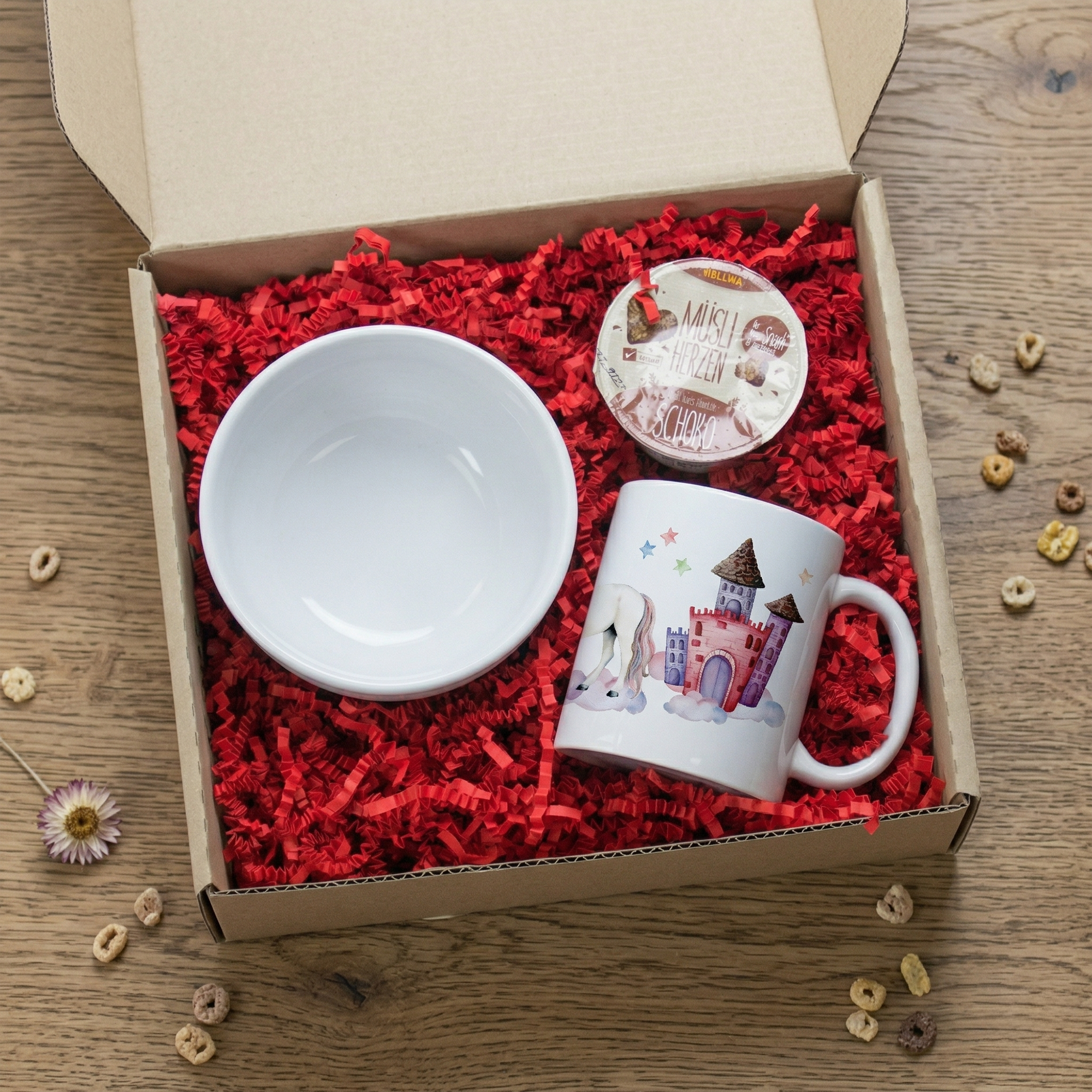 Tasse mit Märchenschloss-Motiv, weiße Schüssel, rotes Füllmaterial.