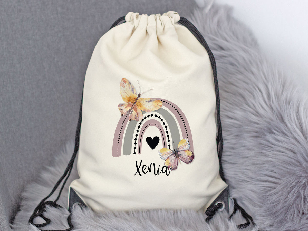 Beige Turnbeutel mit Regenbogen, Schmetterlingen und Namen Xenia.