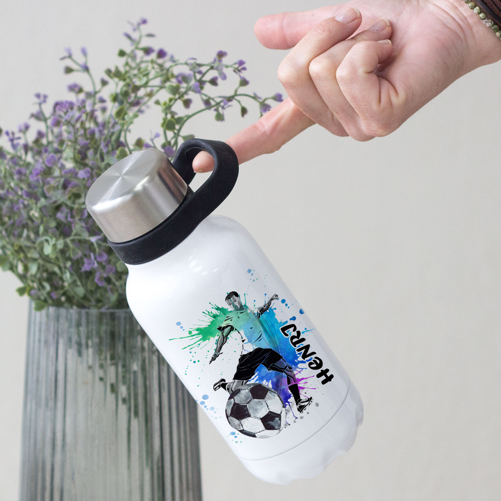 Weiße Sportflasche mit Fußball-Motiv und bunten Spritzern.
