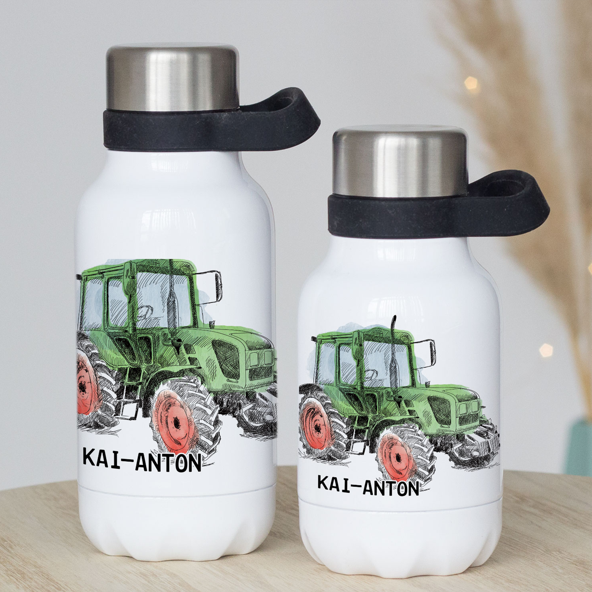 Grüne Trinkflasche mit Traktor-Design und schwarzem Deckel.