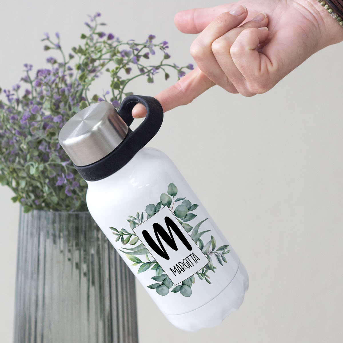 Weiße Wasserflasche mit grünem Eukalyptus-Design und Metallverschluss.
