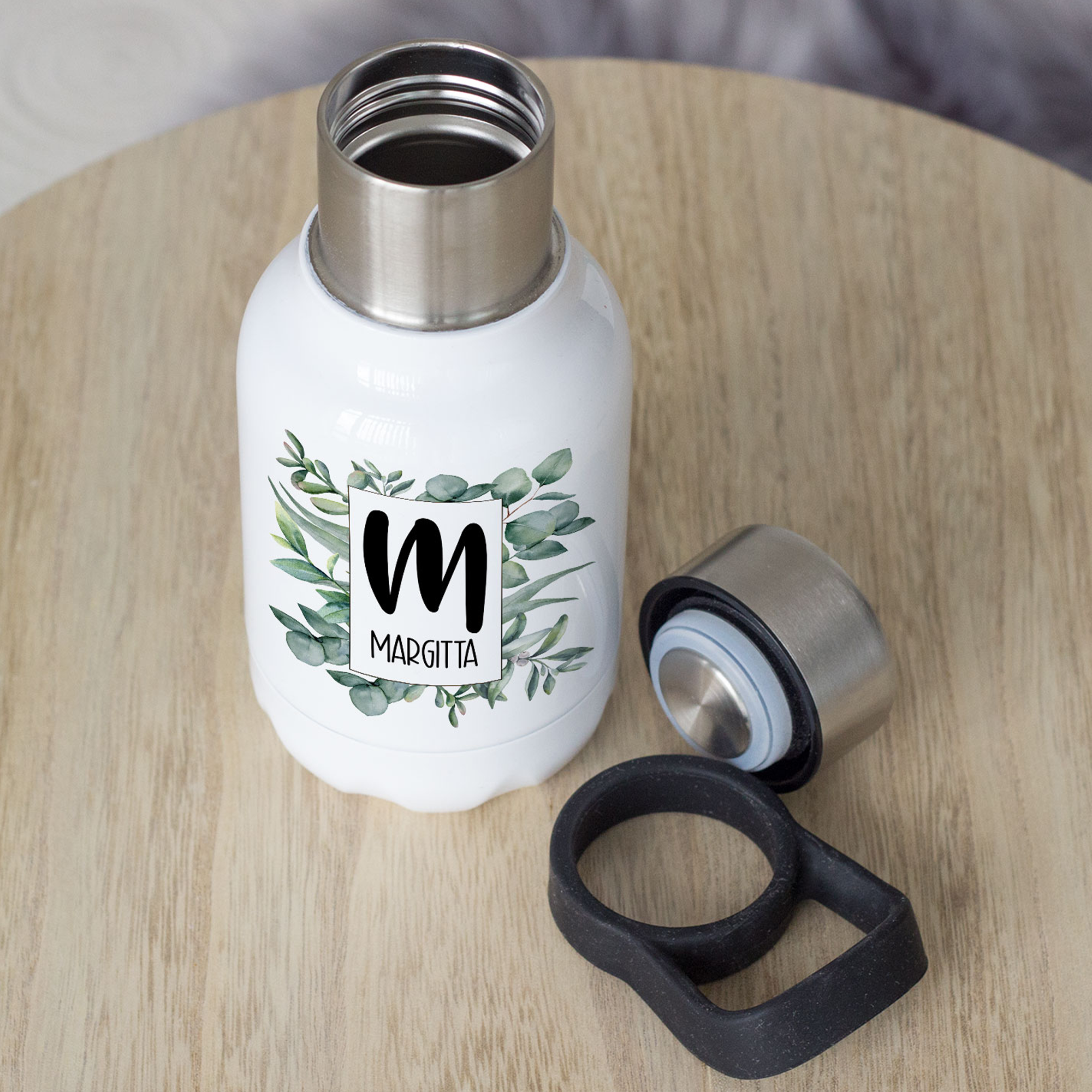 Weiße Trinkflasche mit grünem Blattdesign und Edelstahlverschluss.