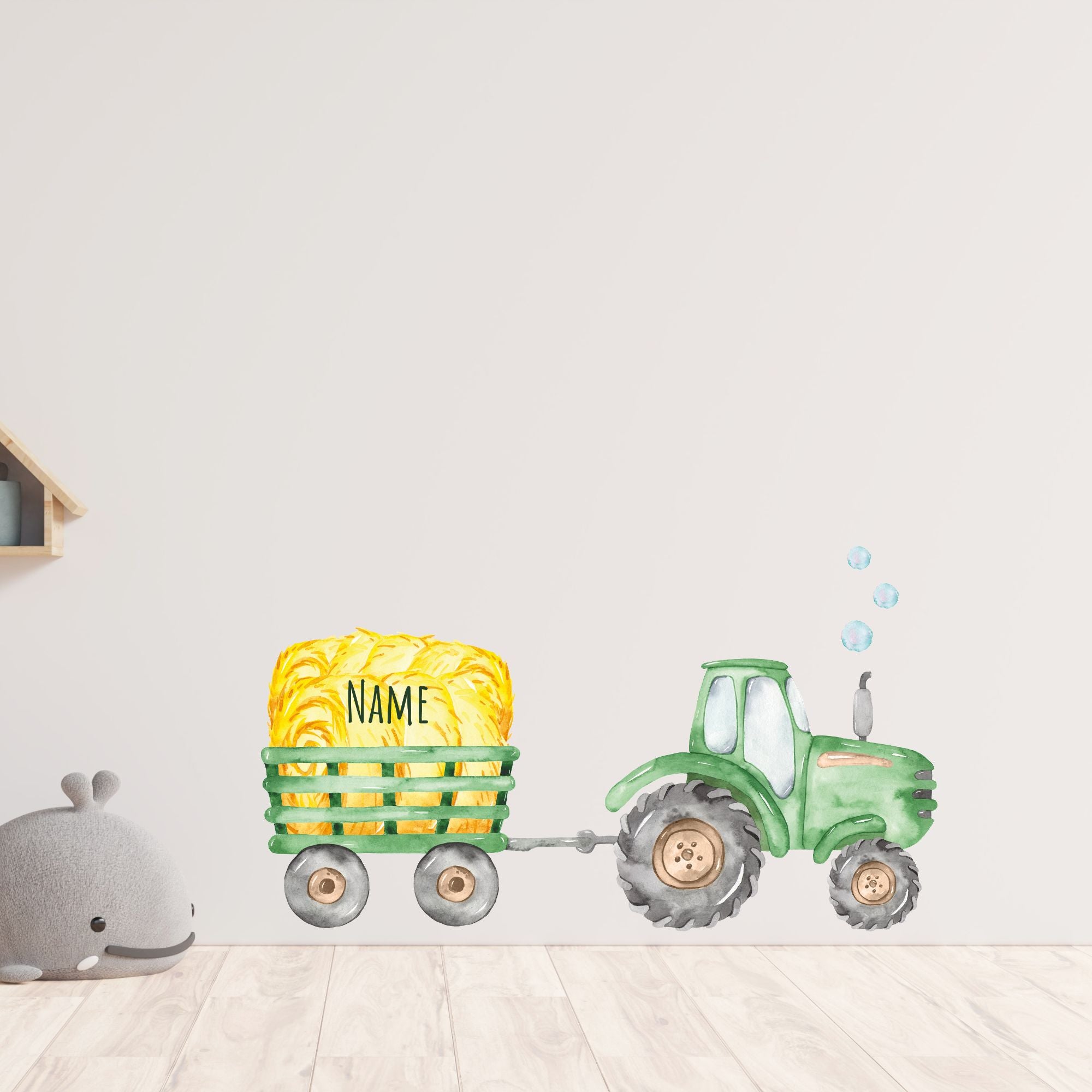 Grüner Traktor mit gelbem Heuballen und Namen.