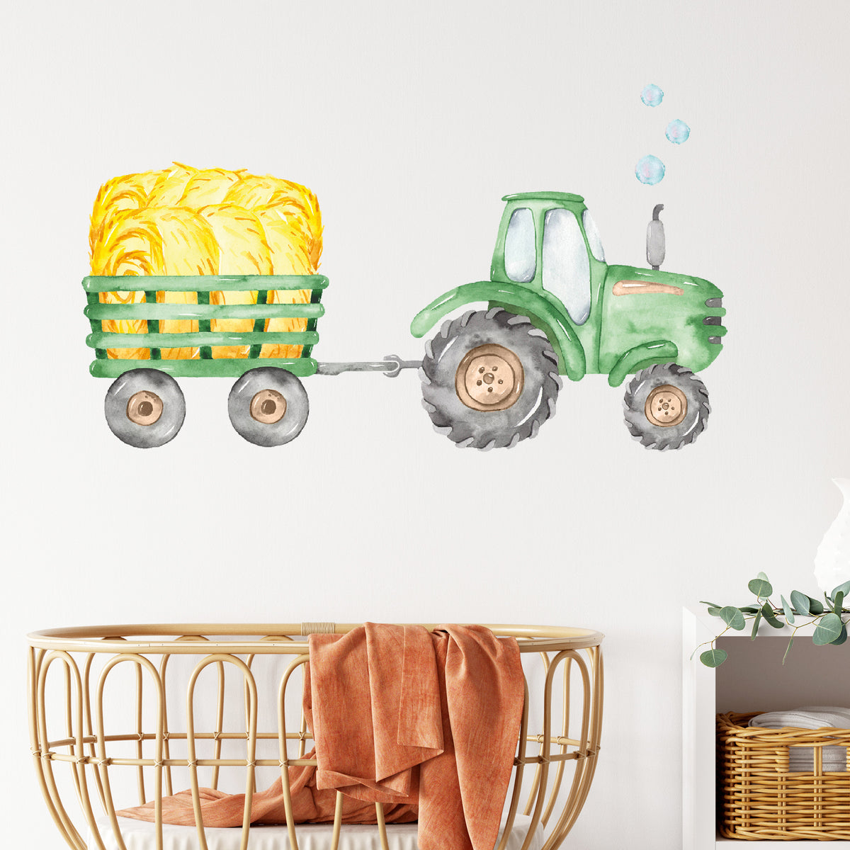 Grüner Traktor mit gelbem Heuballen auf Anhänger.