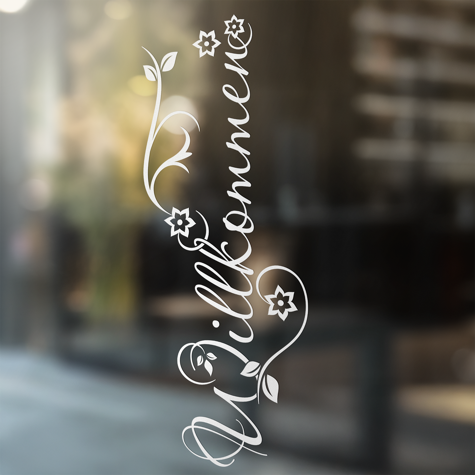 Willkommen Schriftzug in Weiß mit floralen Elementen.