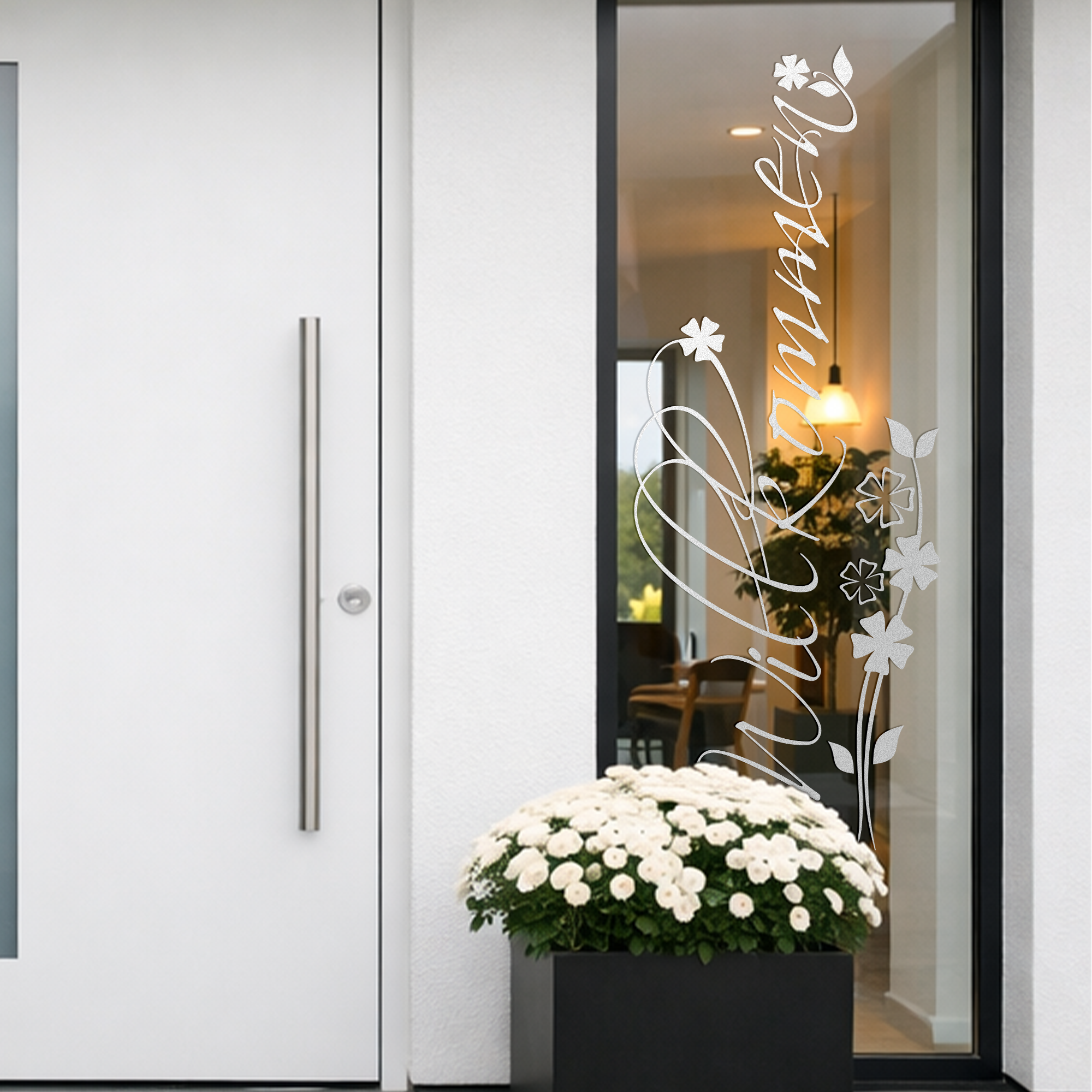 Weiße Haustür mit dekorativem "Willkommen"-Schild und Blumen.