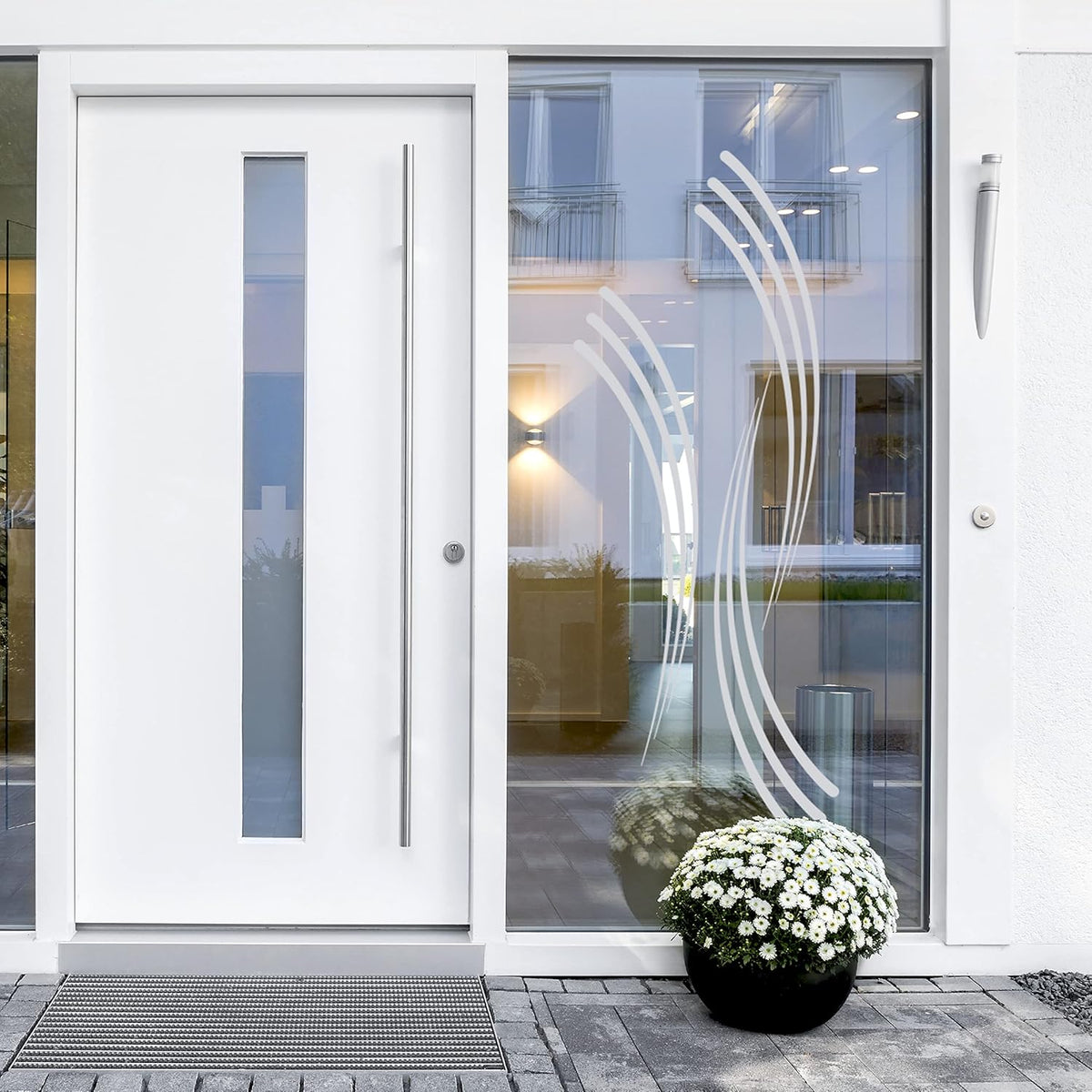 Weiße Haustür mit dekorativem Glas und Blumentopf.