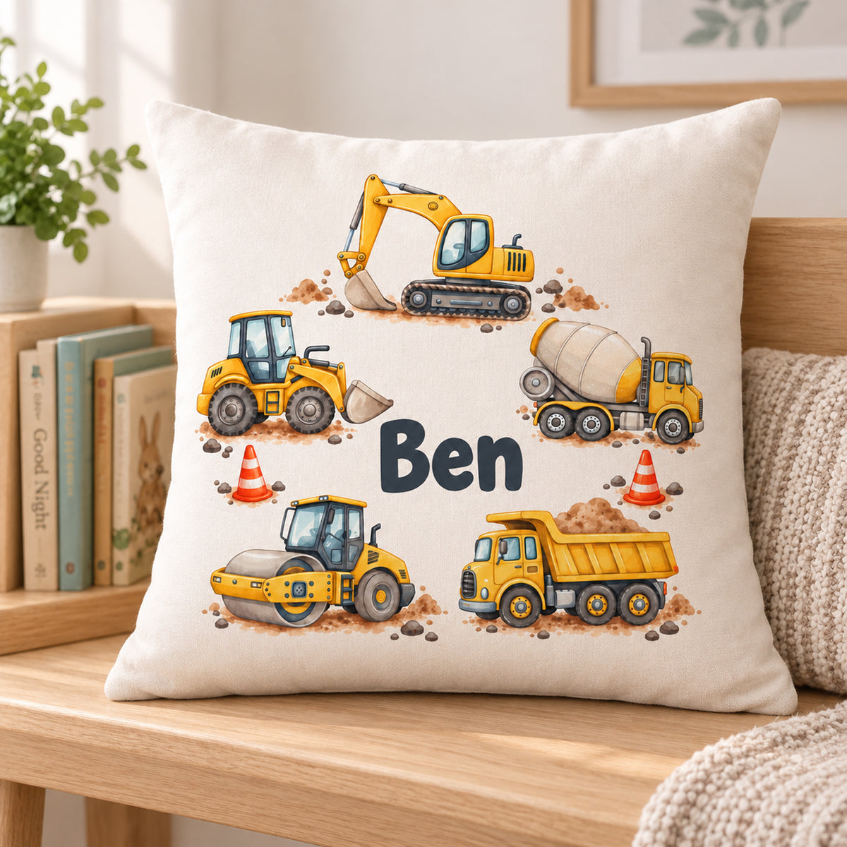Kissenbezug mit Baustellenfahrzeugkranz und Beispielname Ben in einer schlichten Leseecke.