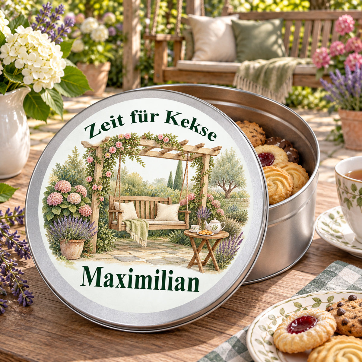 Offene Keksdose mit Keksen und daneben aufgestelltem bedrucktem Deckel mit Motiv Gemütliche Gartenschaukel