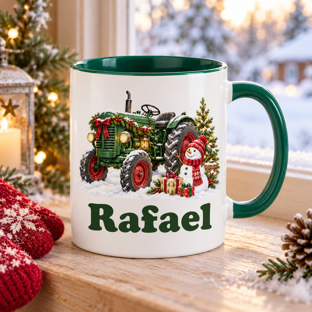Weiße Tasse mit grünem Henkel und Innenraum, Trecker mit Schneemann und Wunschname schräg auf einem Holztisch.