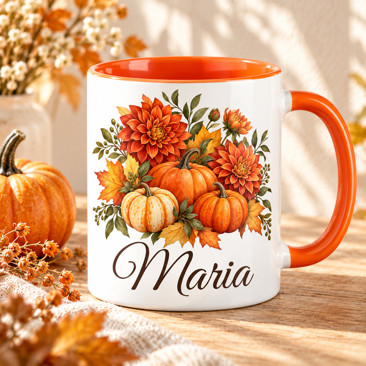 Personalisierte Herbsttasse mit Kürbissen, Dahlien und Herbstlaub auf hellem Holztisch, mit orangefarbenem Henkel und Innenbereich.