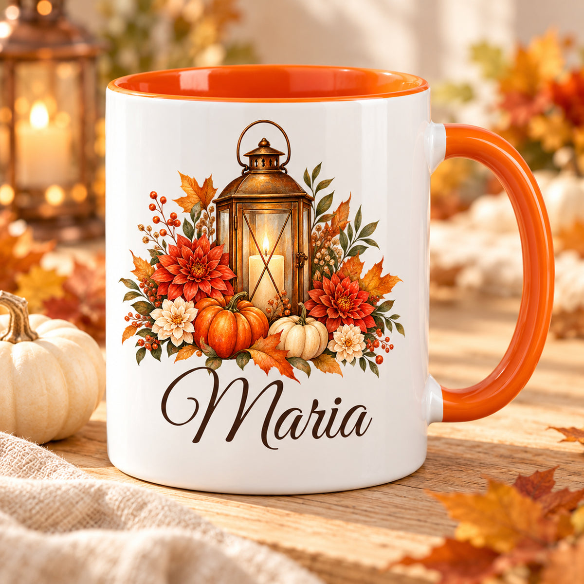 Personalisierte Herbsttasse mit Laterne, Kürbissen und Blumen sowie orangefarbenem Henkel auf einem Holztisch.