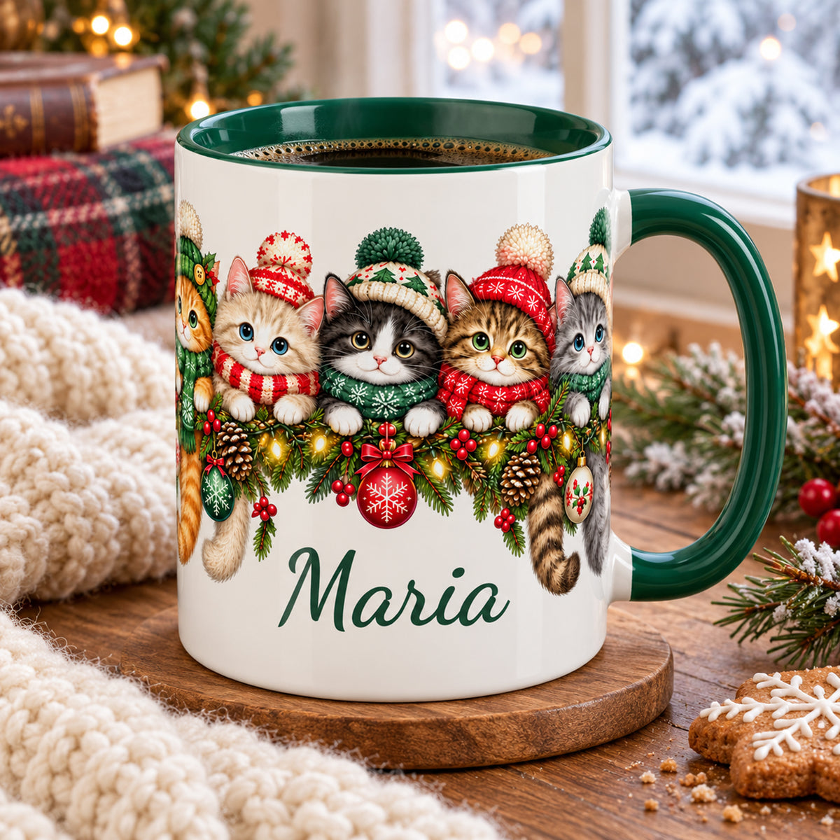Mit Kaffee gefüllte Weihnachtstasse mit Katzen, grünem Inneren und Wunschname auf einem weihnachtlich dekorierten Holztisch.