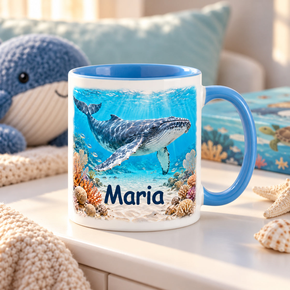 Wal-Tasse im Korallenriff mit Name Maria in einer Leseecke mit Buch und Stoffwal