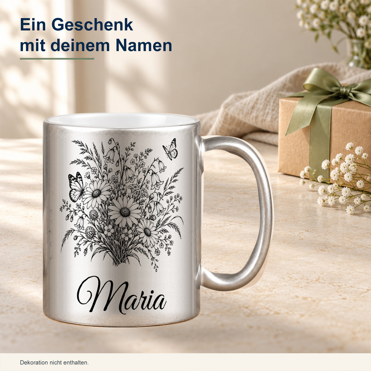 Silberne Tasse mit schwarzem Schmetterlings- und Wiesenblumenmotiv und Wunschnamen als persönliche Geschenkidee in dekorierter Umgebung.