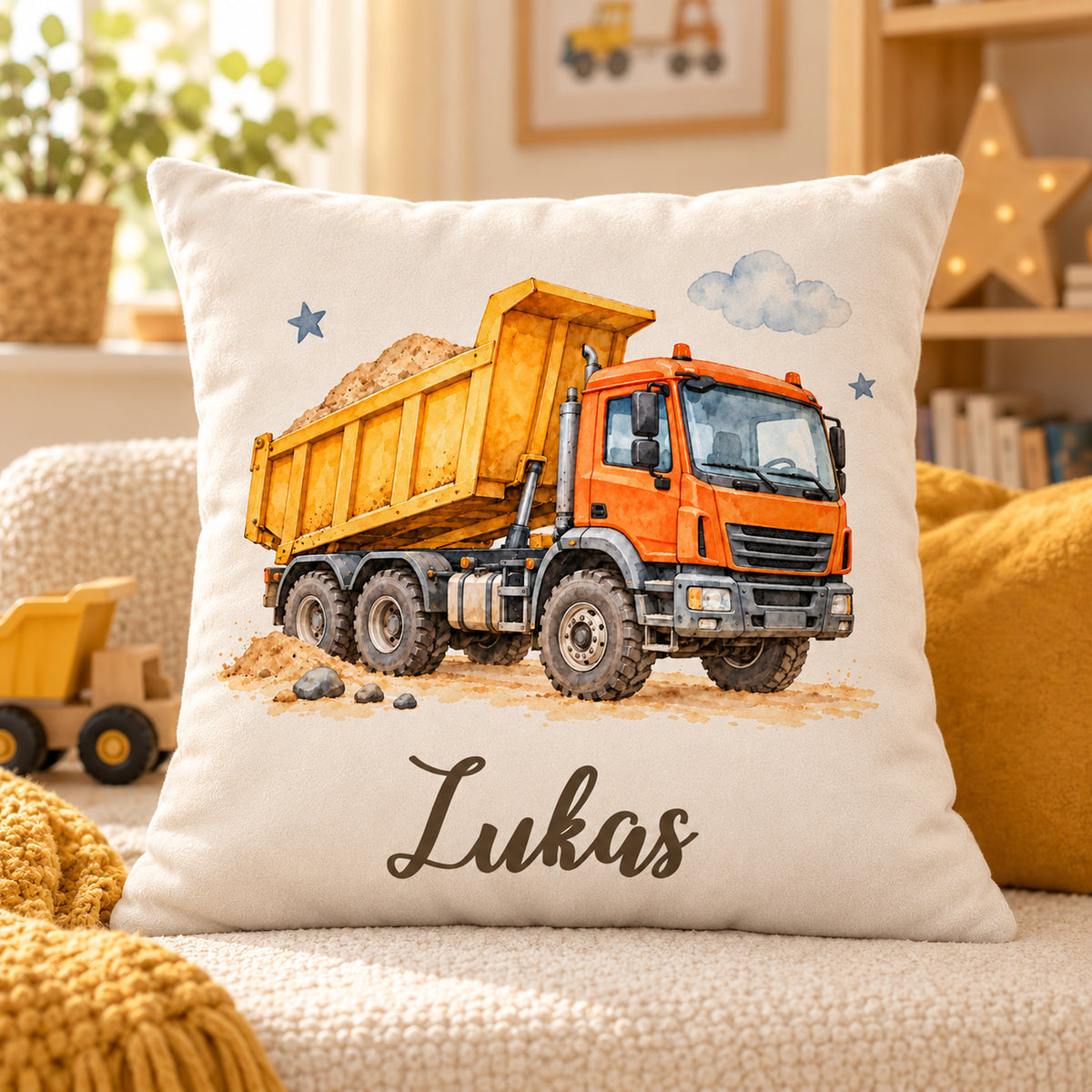 Kipplaster-Kissen mit Namen Lukas auf einer hellen Sitzfläche neben einer senfgelben Decke.