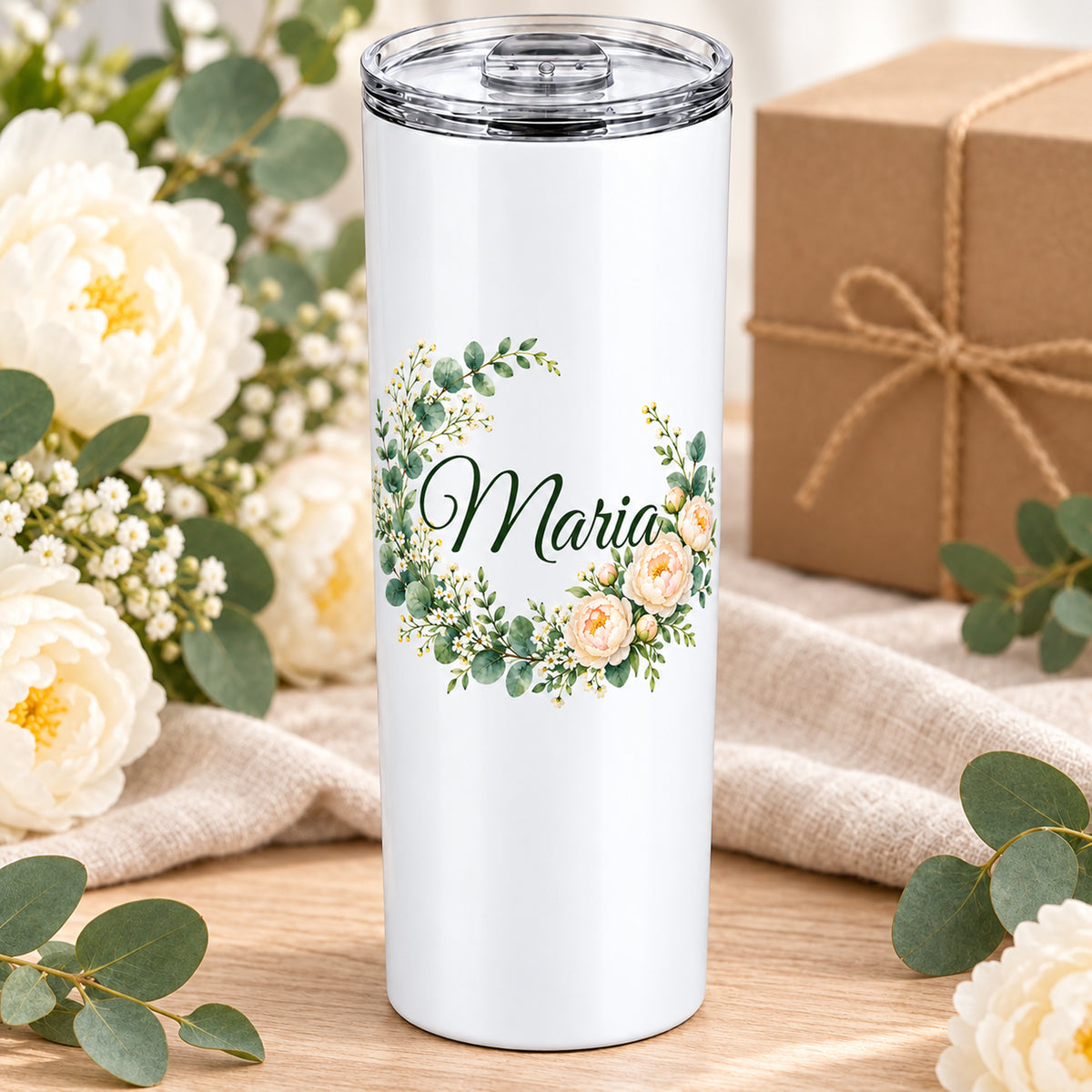 Weißer Thermobecher mit Motiv Pfingstrosenkranz, Blumenranke und Name Wunschname auf einem dekorierten Geschenktisch.