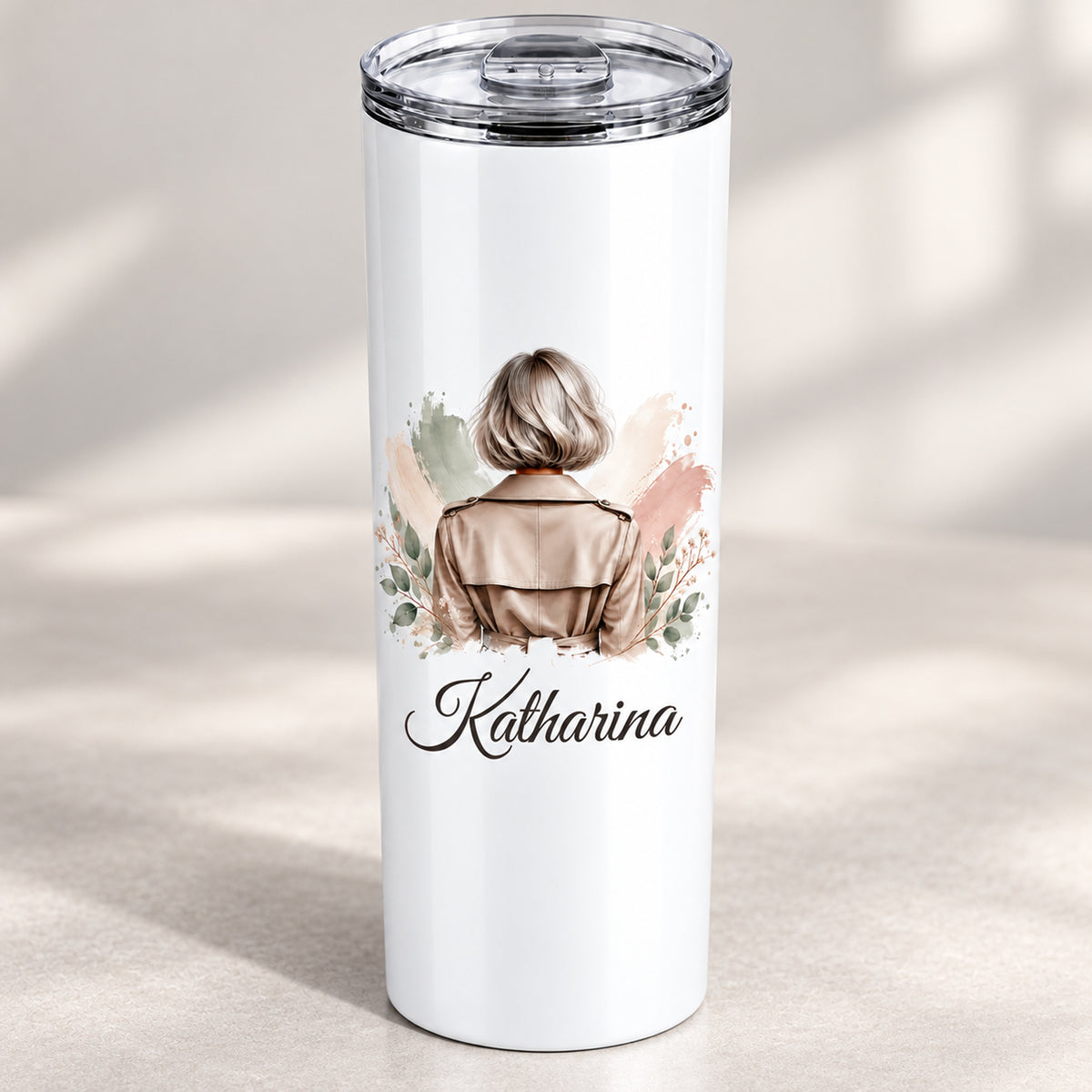 Nahansicht des Frauenmotivs mit silbergrauem Bob und taupefarbenem Trenchcoat und personalisiertem Namen auf dem weißen Thermobecher.
