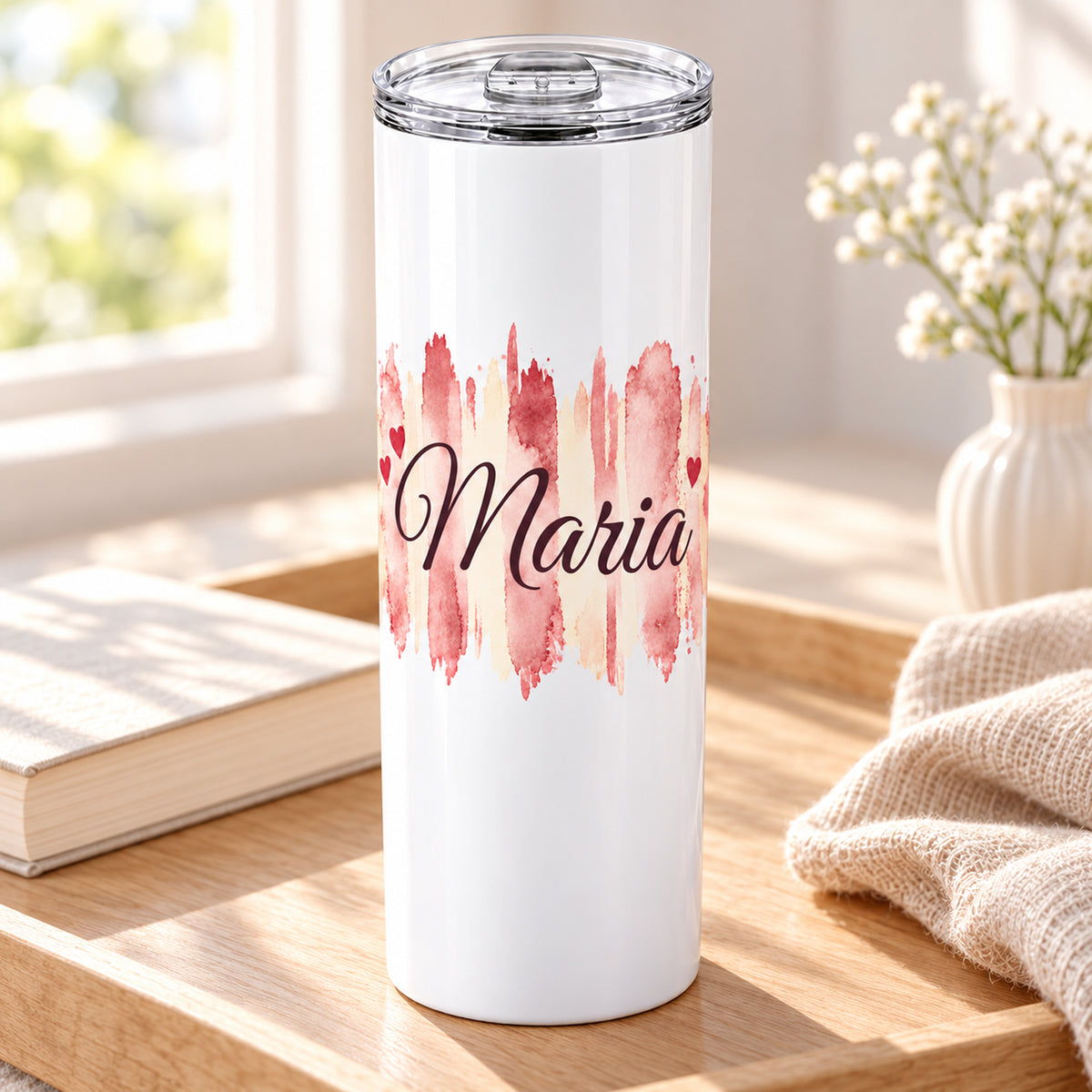 Weißer Thermobecher mit Motiv Herzensrosa, personalisiertem Namen in einer wohnlichen Umgebung.