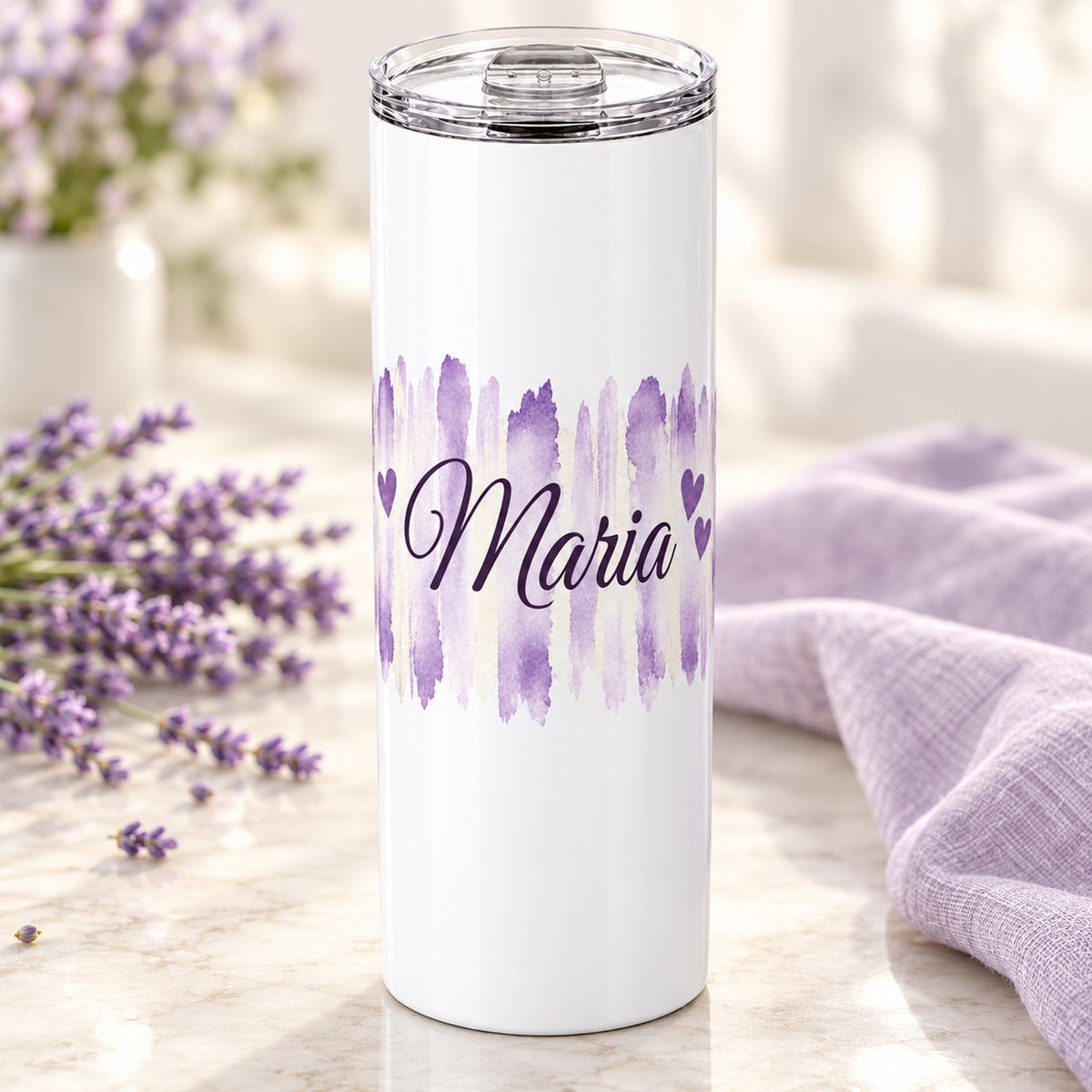 Weißer Thermobecher mit Motiv Fliederliebe, personalisiertem Namen auf einem dekorierten Geschenktisch.