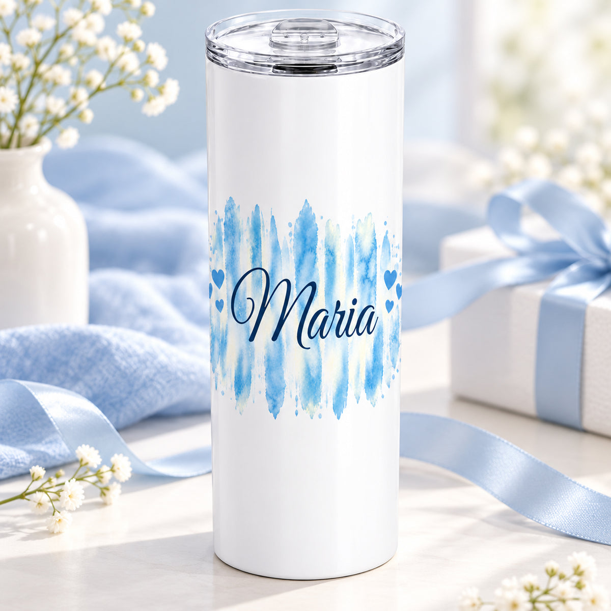 Weißer Thermobecher mit Motiv Himmelherz, personalisiertem Namen auf einem dekorierten Geschenktisch.