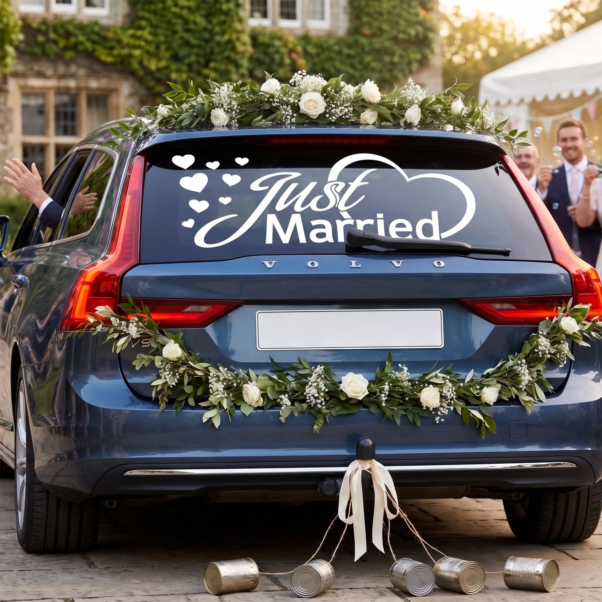 Blauer Volvo mit Hochzeitsdekoration und "Just Married"-Aufkleber.