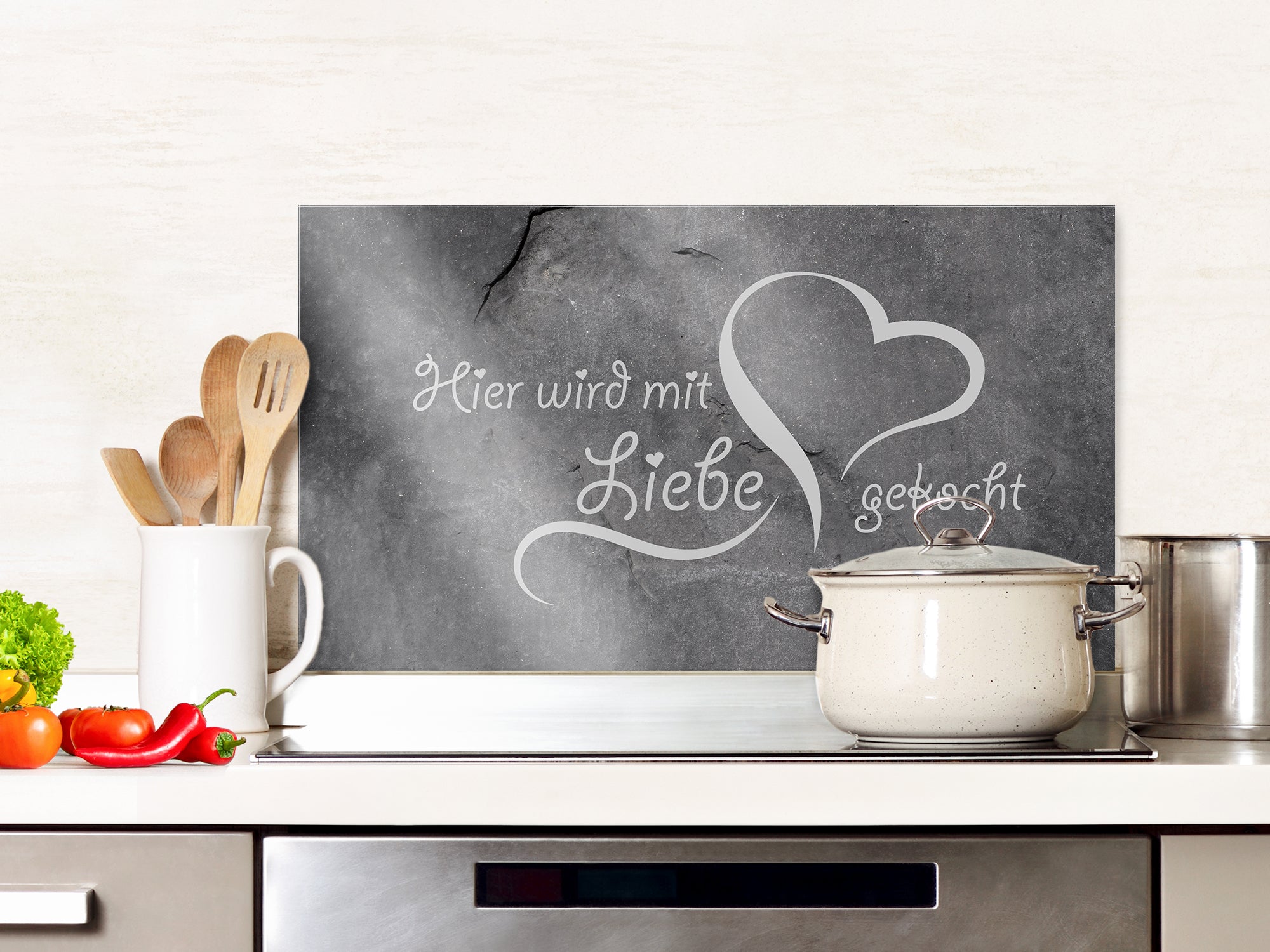 Schieferplatte mit Schriftzug „Hier wird mit Liebe gekocht“.