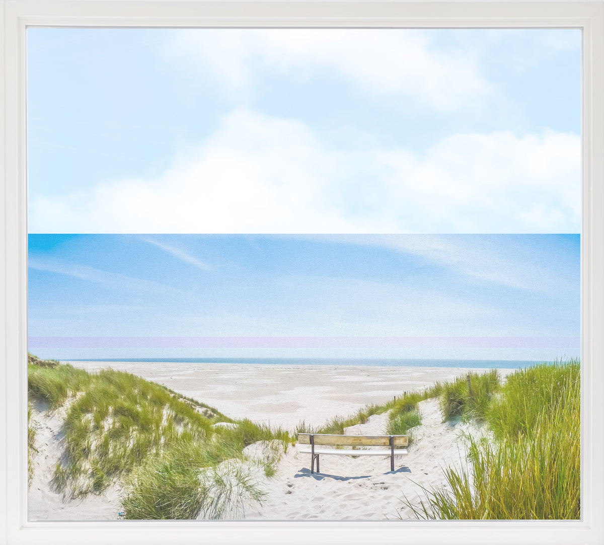 Strandlandschaft mit Bank, blauer Himmel und grünem Gras.