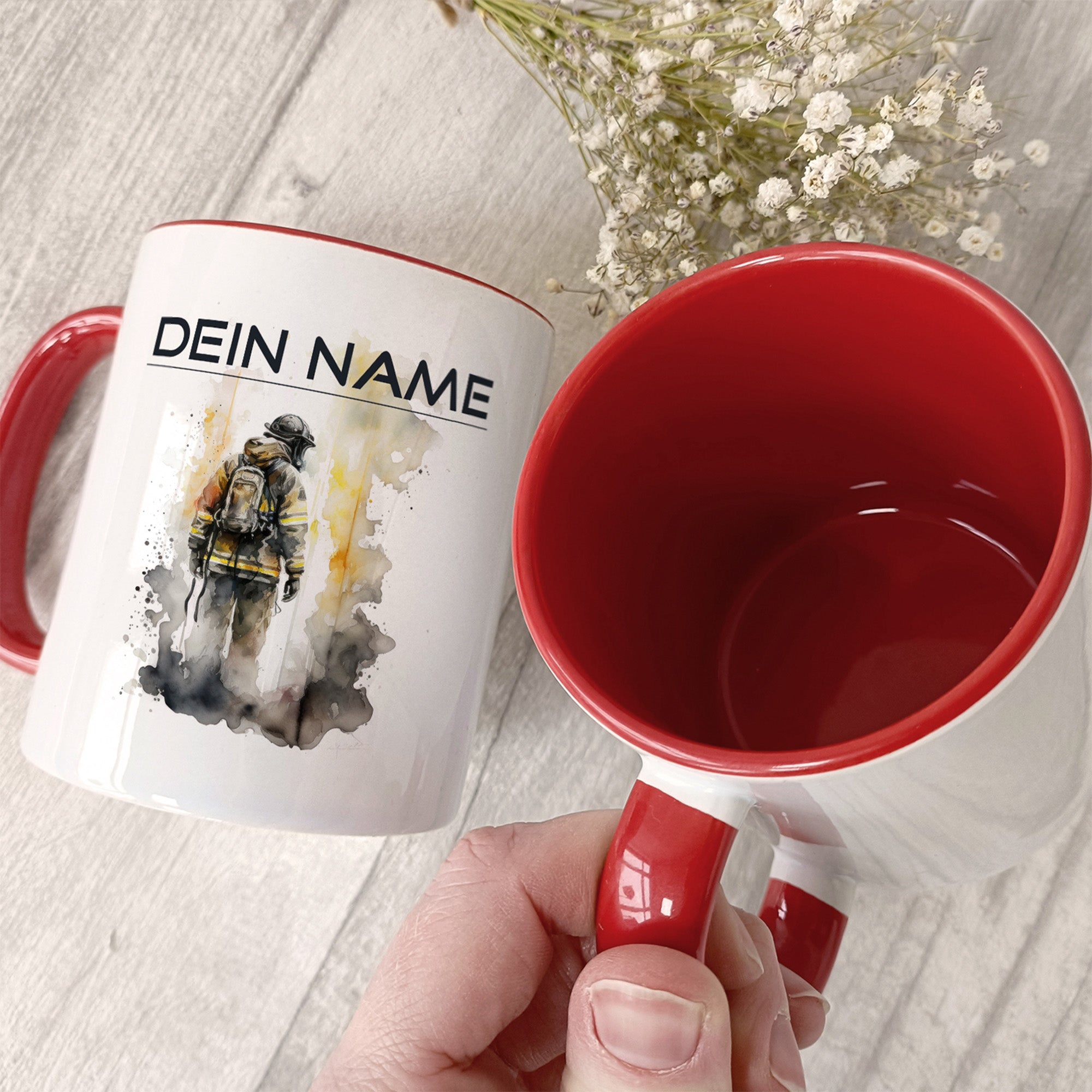 Kaffeetasse mit rotem Henkel und Feuerwehrmann-Illustration.