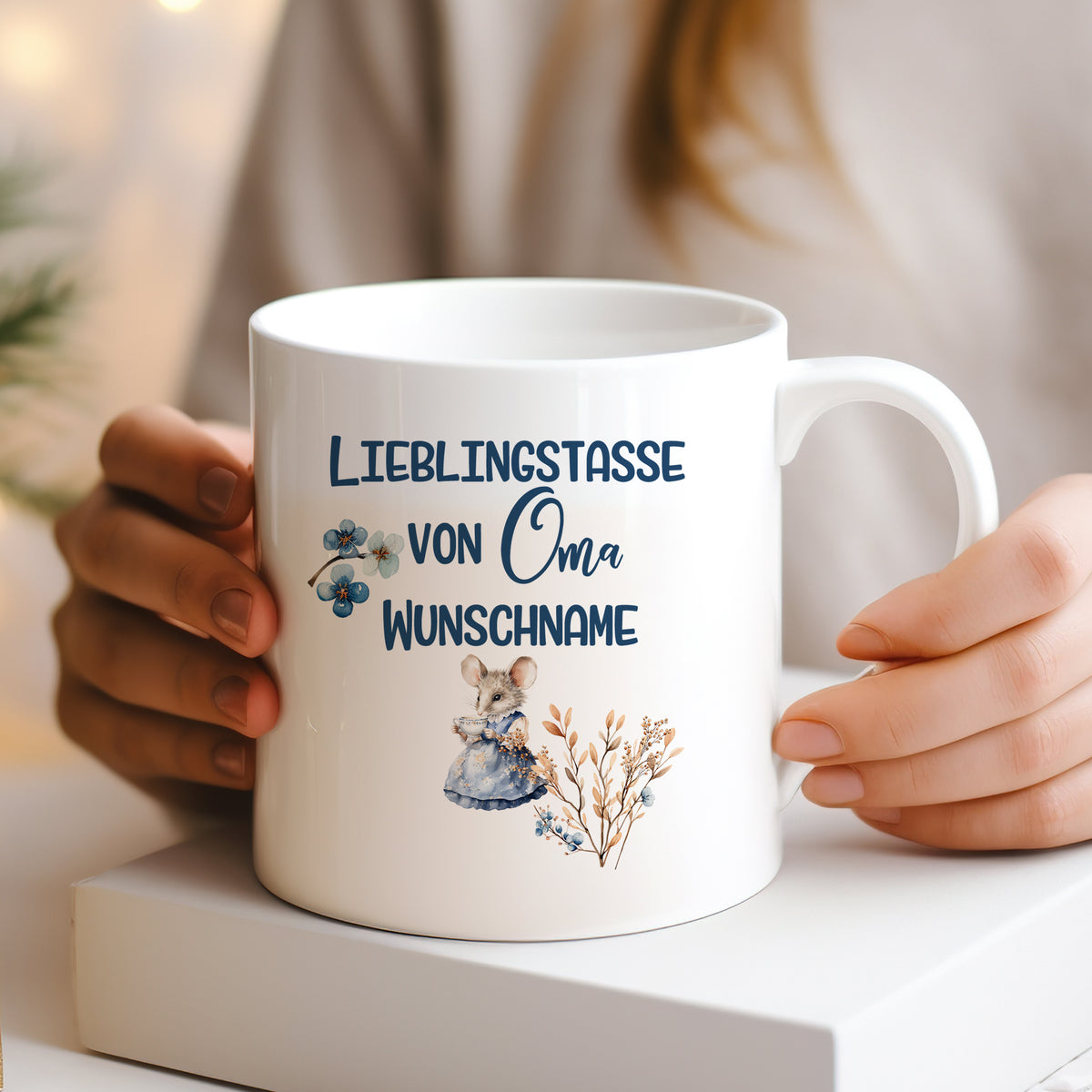 Weiße Tasse mit "Lieblingstasse von Oma" und Blumenmotiven.