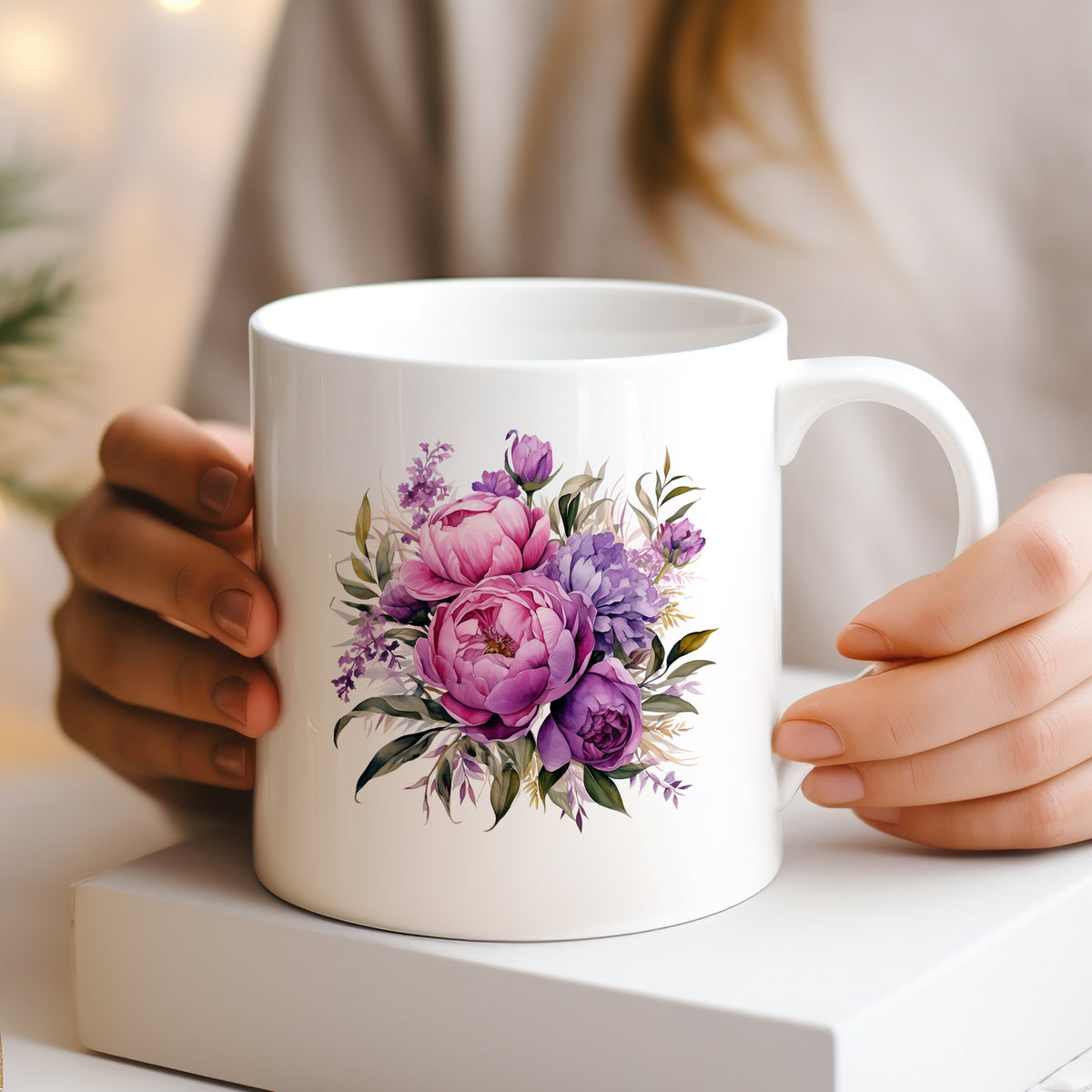 Weiße Tasse mit lila und rosa Blumenmuster.