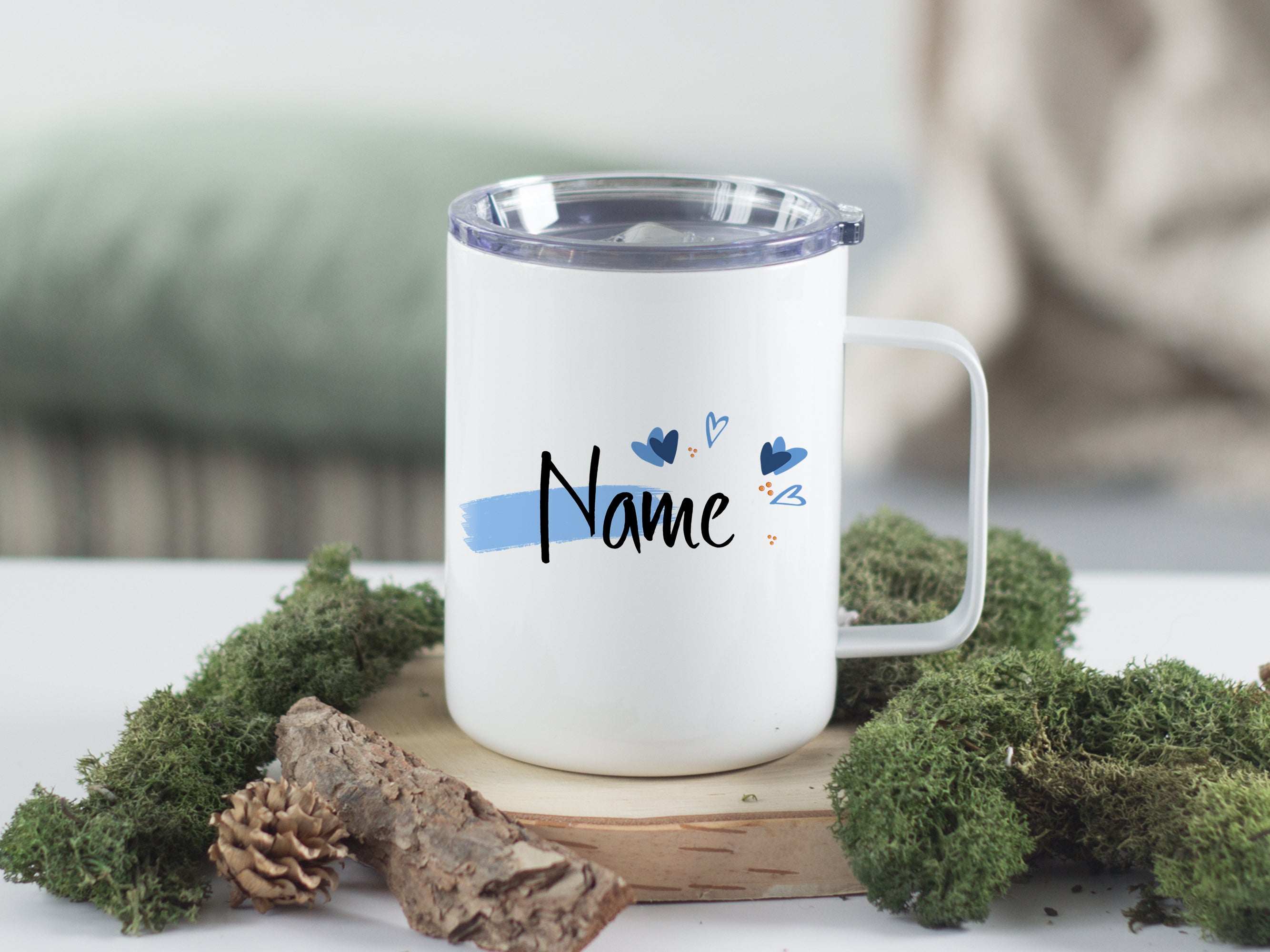 Weißer Becher mit personalisiertem Namen und blauen Akzenten.