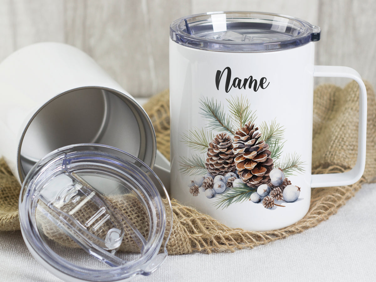 Weißer Becher mit Tannenzapfen und personalisierbarem Namen.