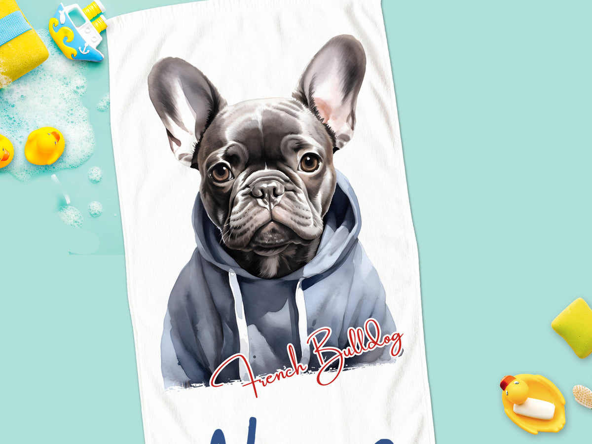 Französische Bulldogge in grauem Hoodie auf Handtuch.