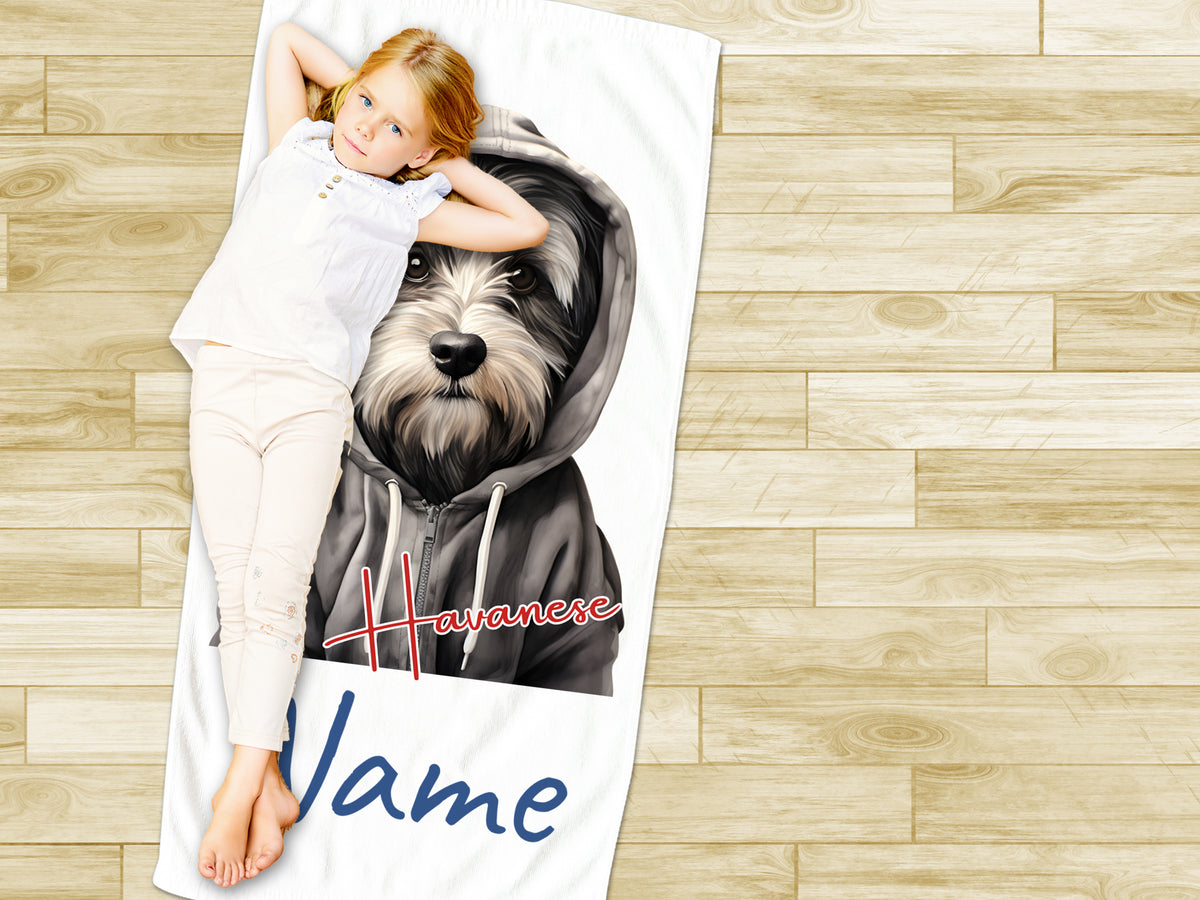 Mädchen auf Handtuch mit Havaneser-Hund und Namen.
