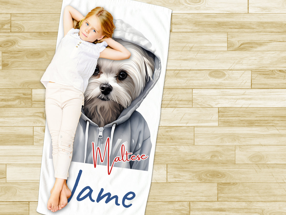 Mädchen liegt auf Handtuch mit Malteser-Hund und Namen.