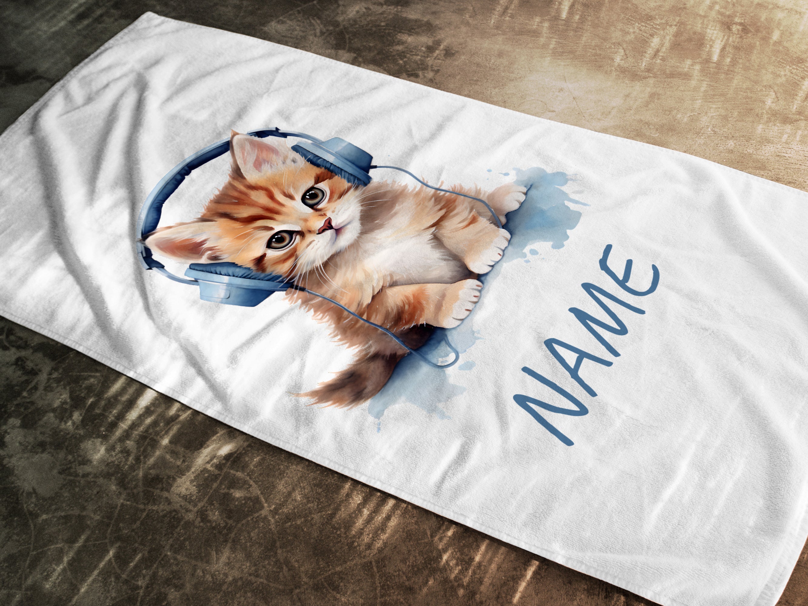 Katze mit Kopfhörern auf weißem Handtuch, personalisierbar.