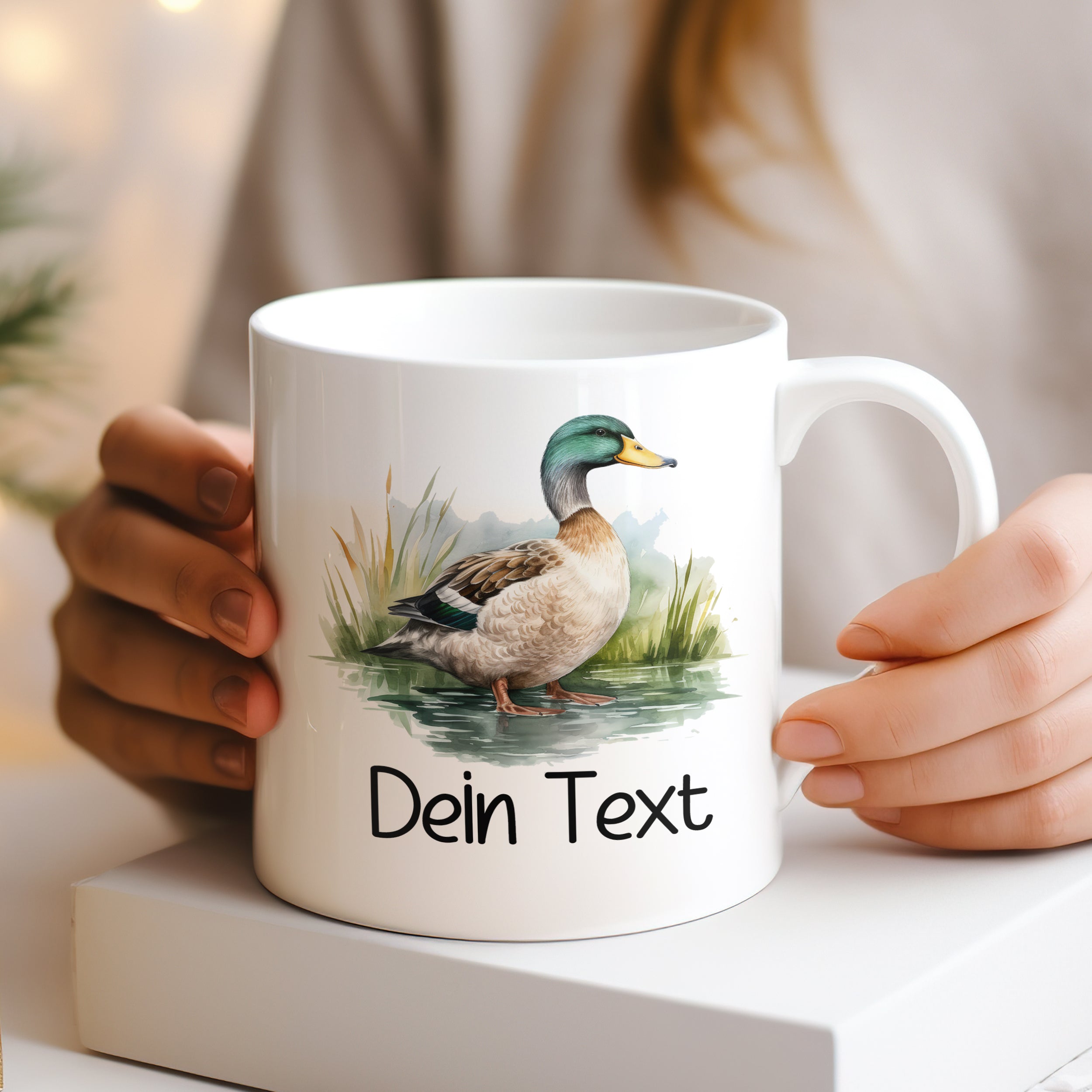 Weißer Becher mit Entenmotiv und personalisiertem Text.
