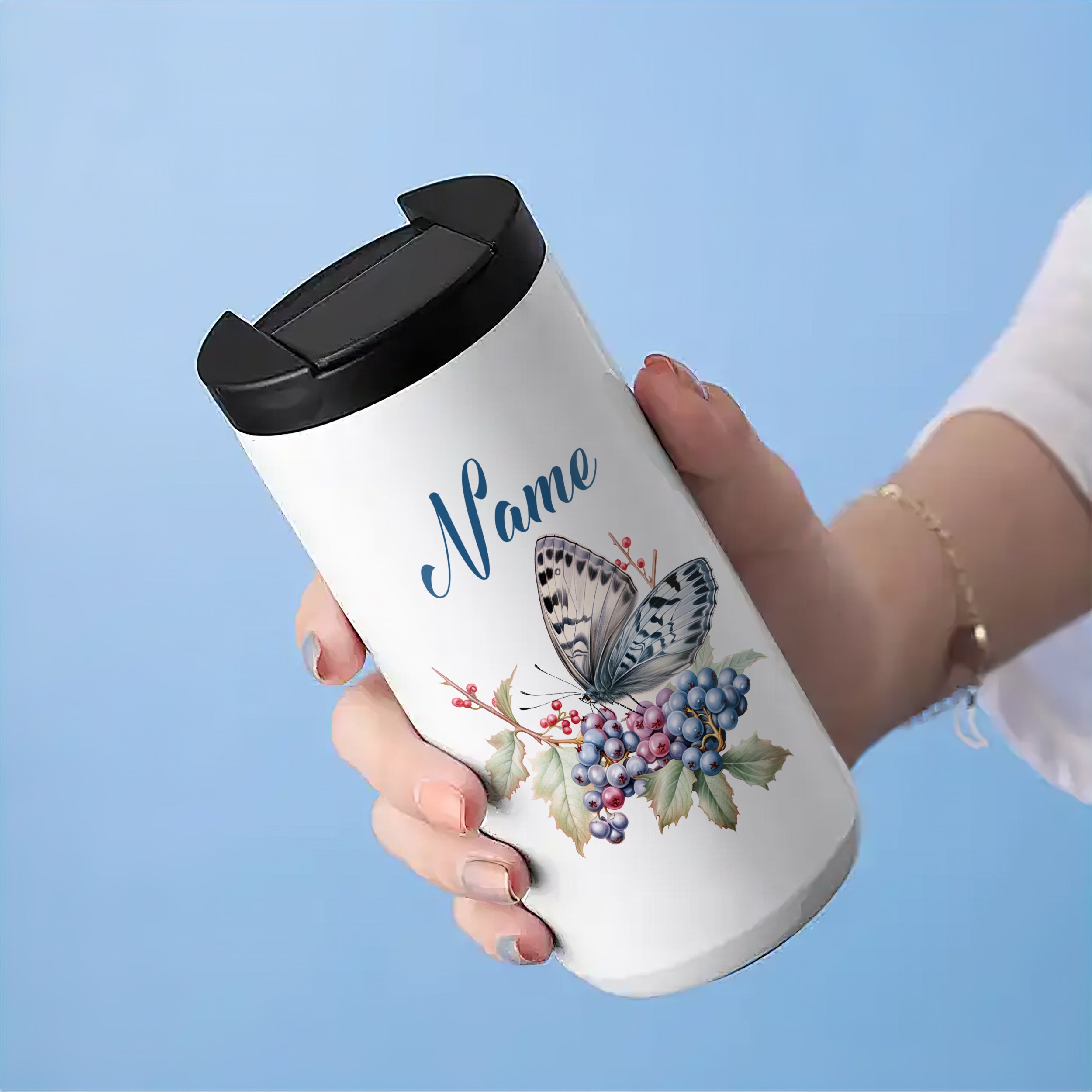 Weißer Thermobecher mit Schmetterling und Blumenmotiv.