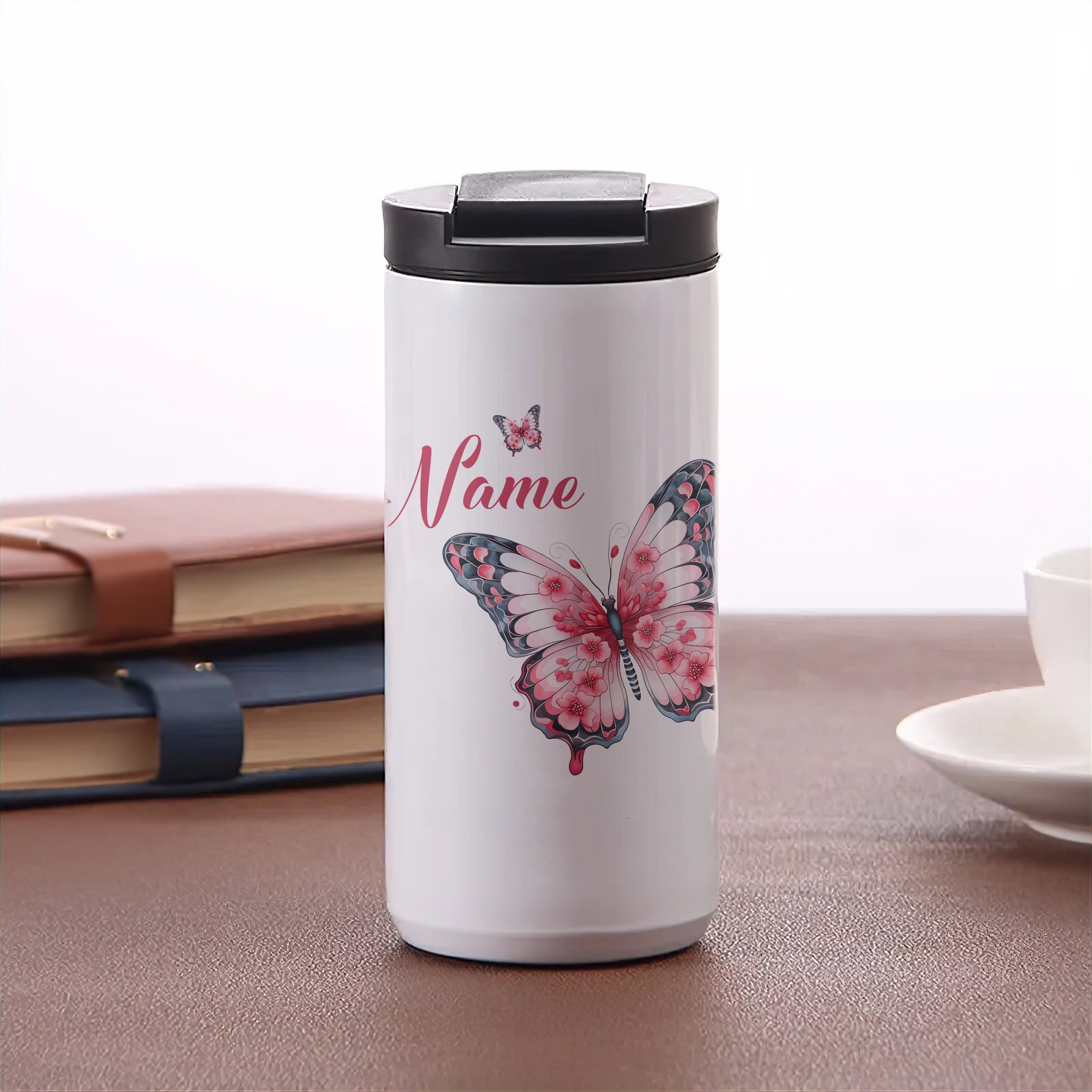 Weißer Becher mit rosa Schmetterling und personalisiertem Namen.